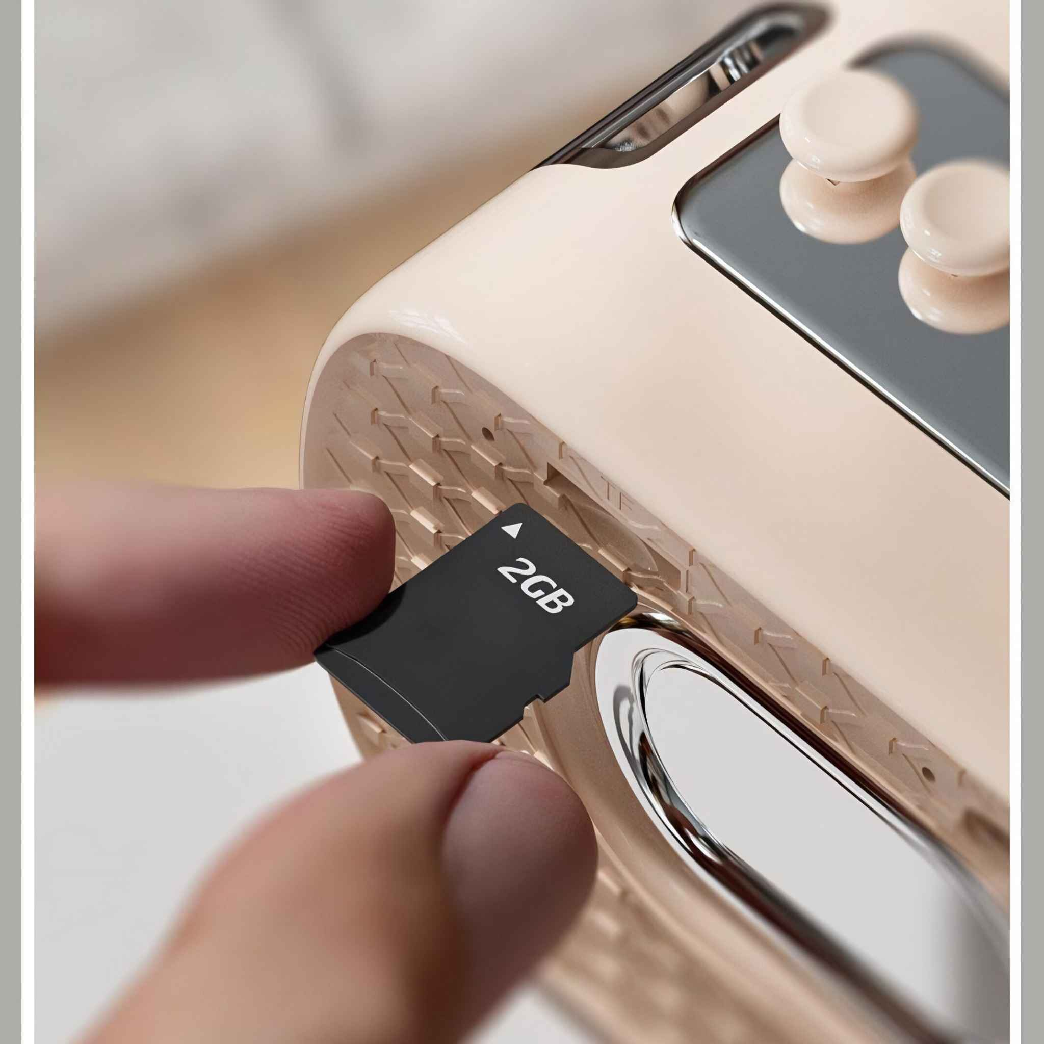 Eine Person steckt eine 2GB SD-Karte in einen Lautsprecher, Nahaufnahme des Steckplatzes und der Karte.