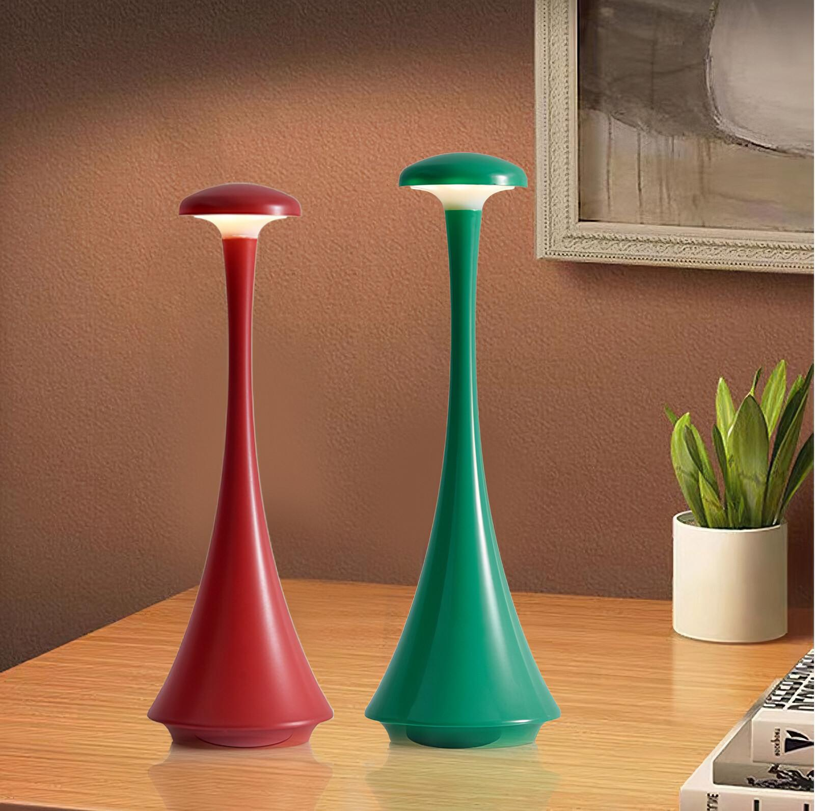 Zwei moderne rote und grüne Lampen auf einer Holzoberfläche. Die Lampen haben ein schlankes Design.
