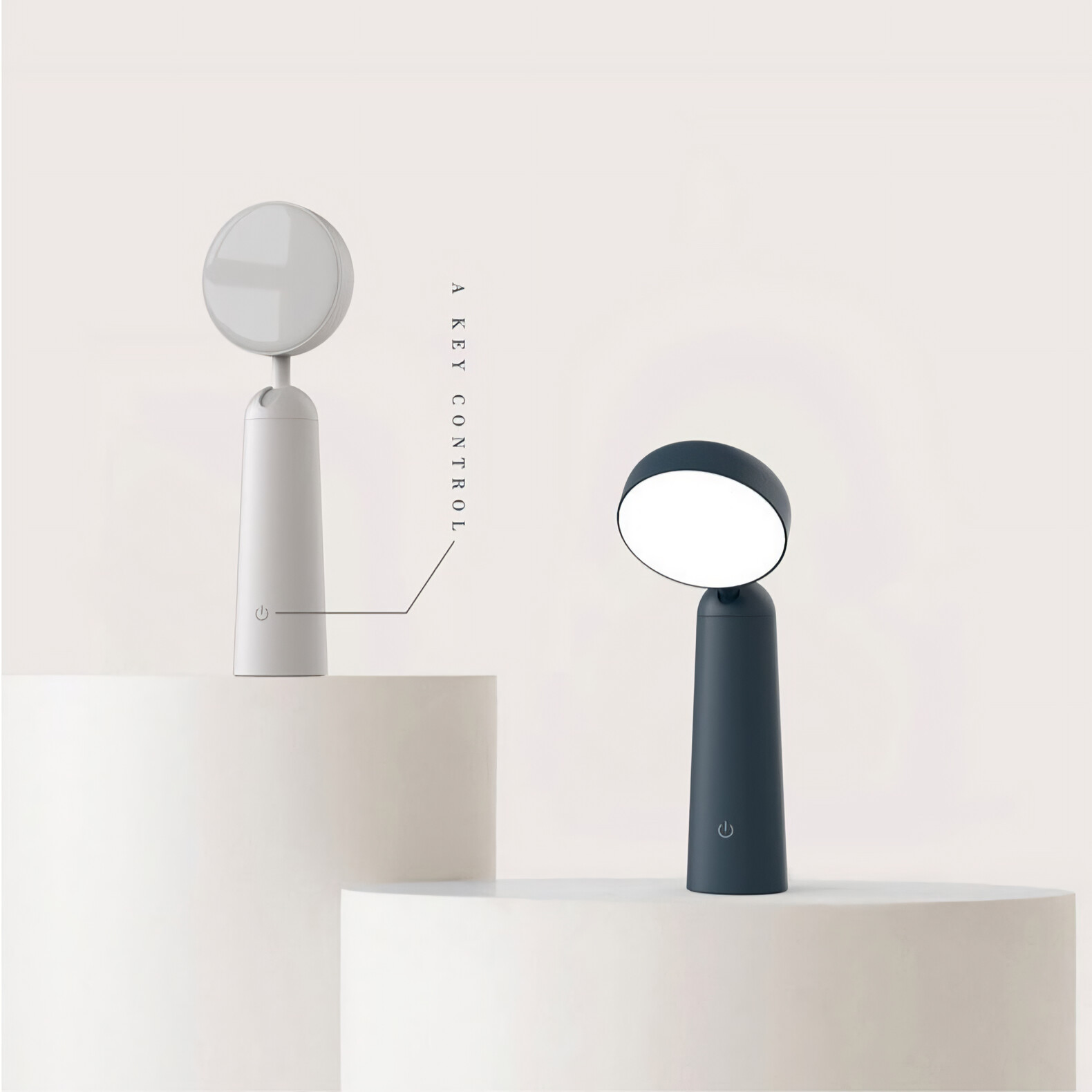 Zwei Lampen auf Podesten. Eine weiß, die andere schwarz. Beide haben einen zylindrischen Sockel und rundes Licht.