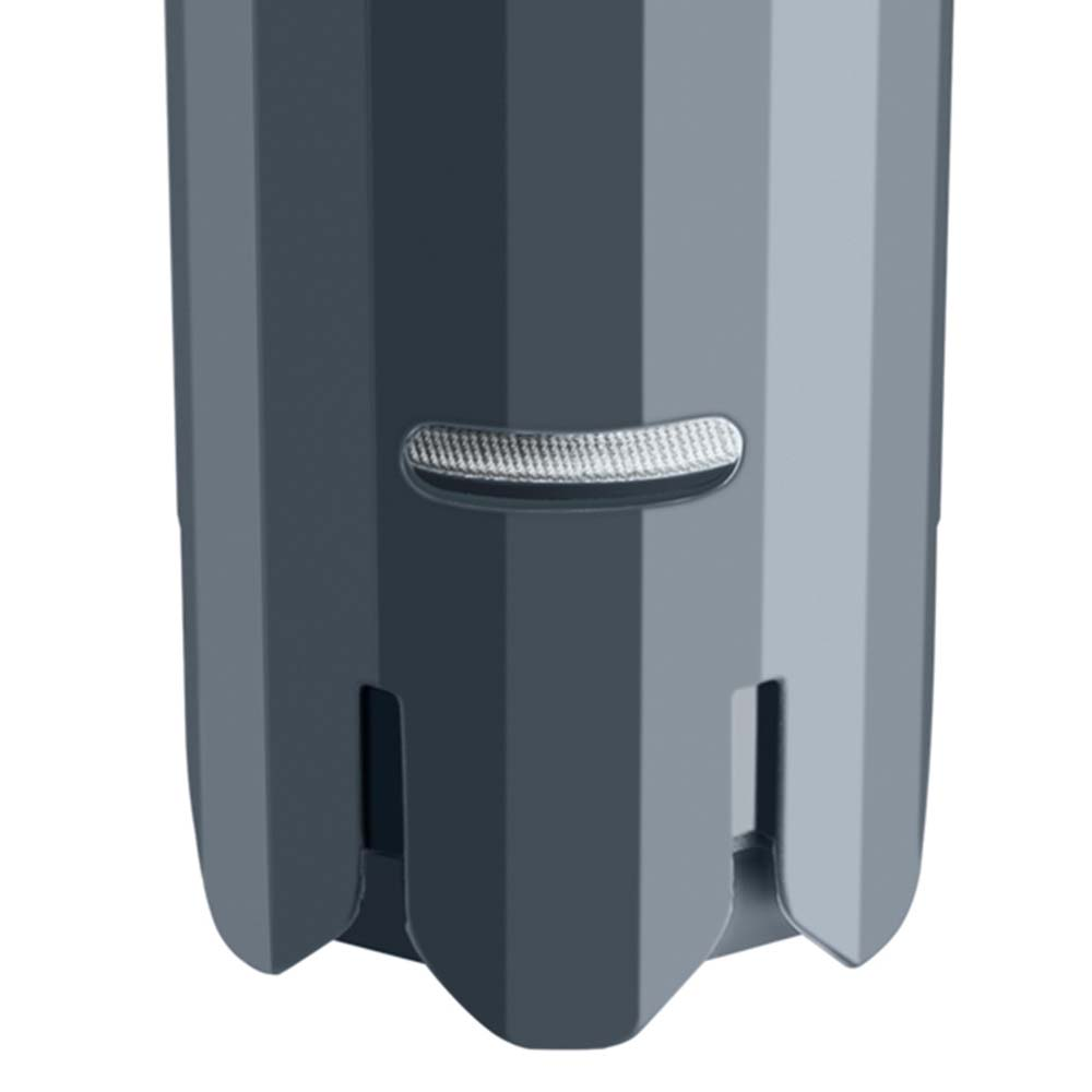 Primer plano de un objeto cilíndrico gris, con costillas verticales y una pequeña abertura horizontal.