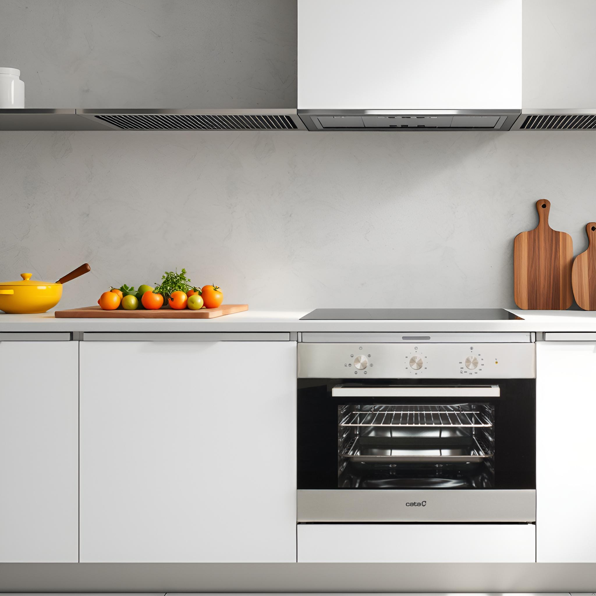 Cucina con mobili bianchi, piano cottura e forno. Verdure e utensili sul bancone.