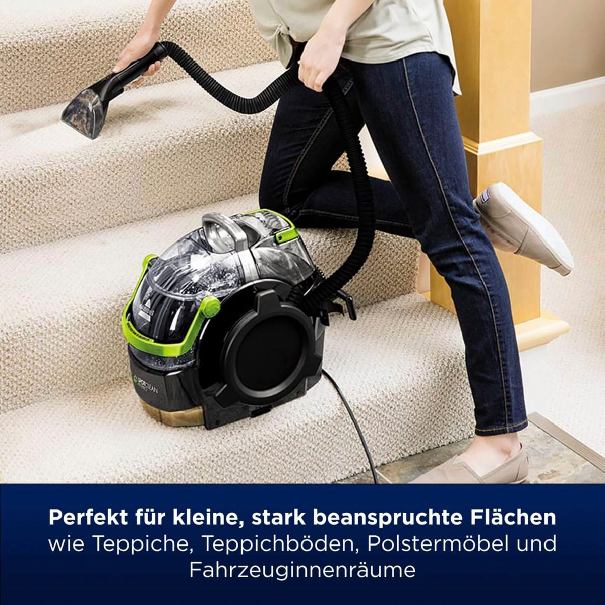 Een persoon die trappen stofzuigt met een Bissell-reiniger. De reiniger is zwart en groen.