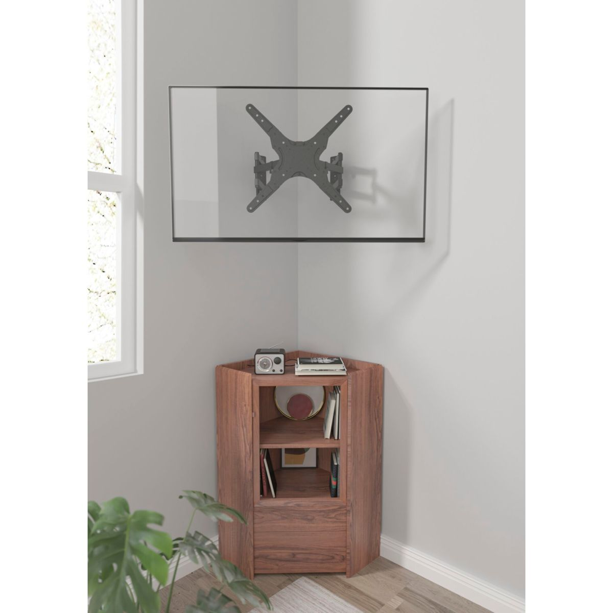 Una TV a schermo piatto montata in un angolo. Sotto, un mobile in legno con radio, libri e oggetti decorativi.