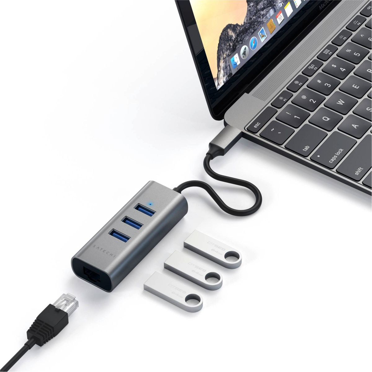 Silberner Hub, verbunden mit Laptop, USB-Laufwerken und Ethernet-Kabel auf weißem Hintergrund.