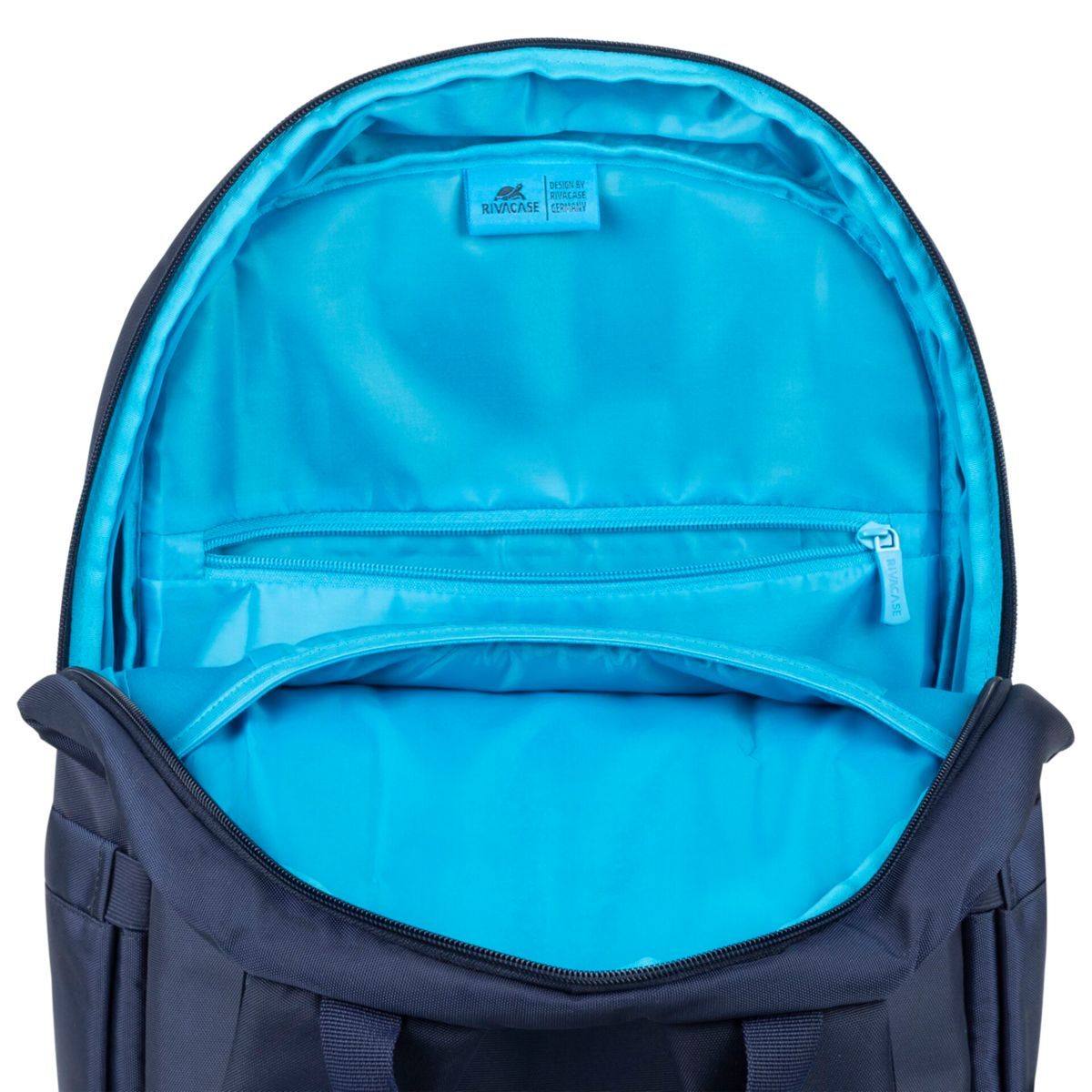 Interno di uno zaino blu navy aperto. Ha una fodera blu brillante, con una tasca con cerniera.