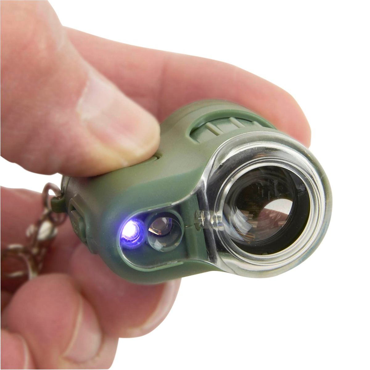 Una mano che tiene una piccola torcia verde. La luce è accesa, mostrando una luce blu.