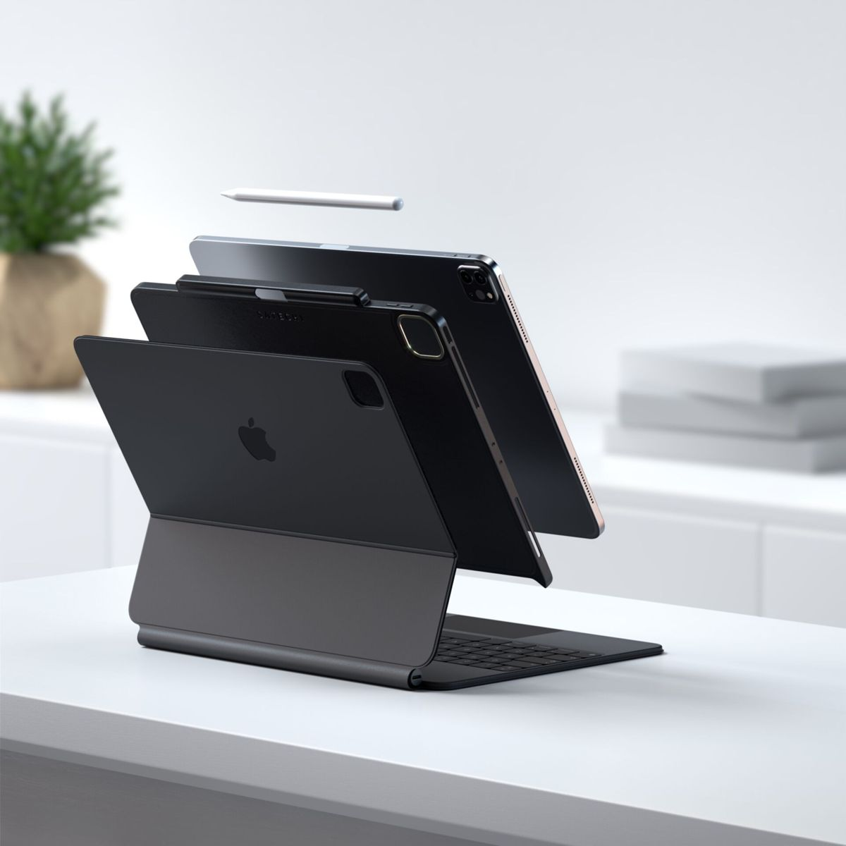 Drei Apple iPads mit Tastaturhüllen, ein weißer Stift. Die iPads sind in einer inszenierten, schwebenden Anzeige angeordnet.