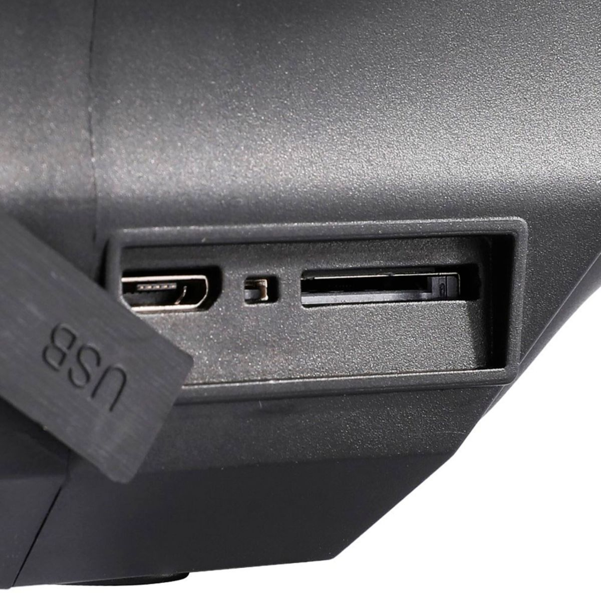Nahaufnahme der USB-, SD-Karten- und anderer Anschlüsse an der Seite eines schwarzen Geräts. Weißer Hintergrund.