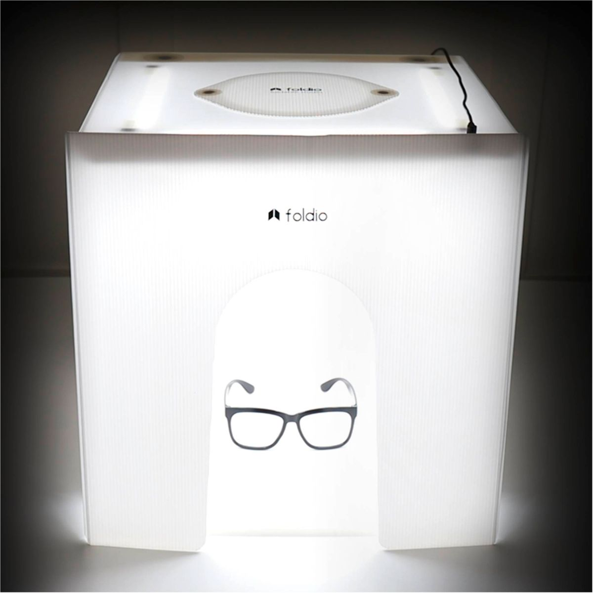 Una caja de luz blanca con gafas dentro y un logotipo de foldio en la parte superior.