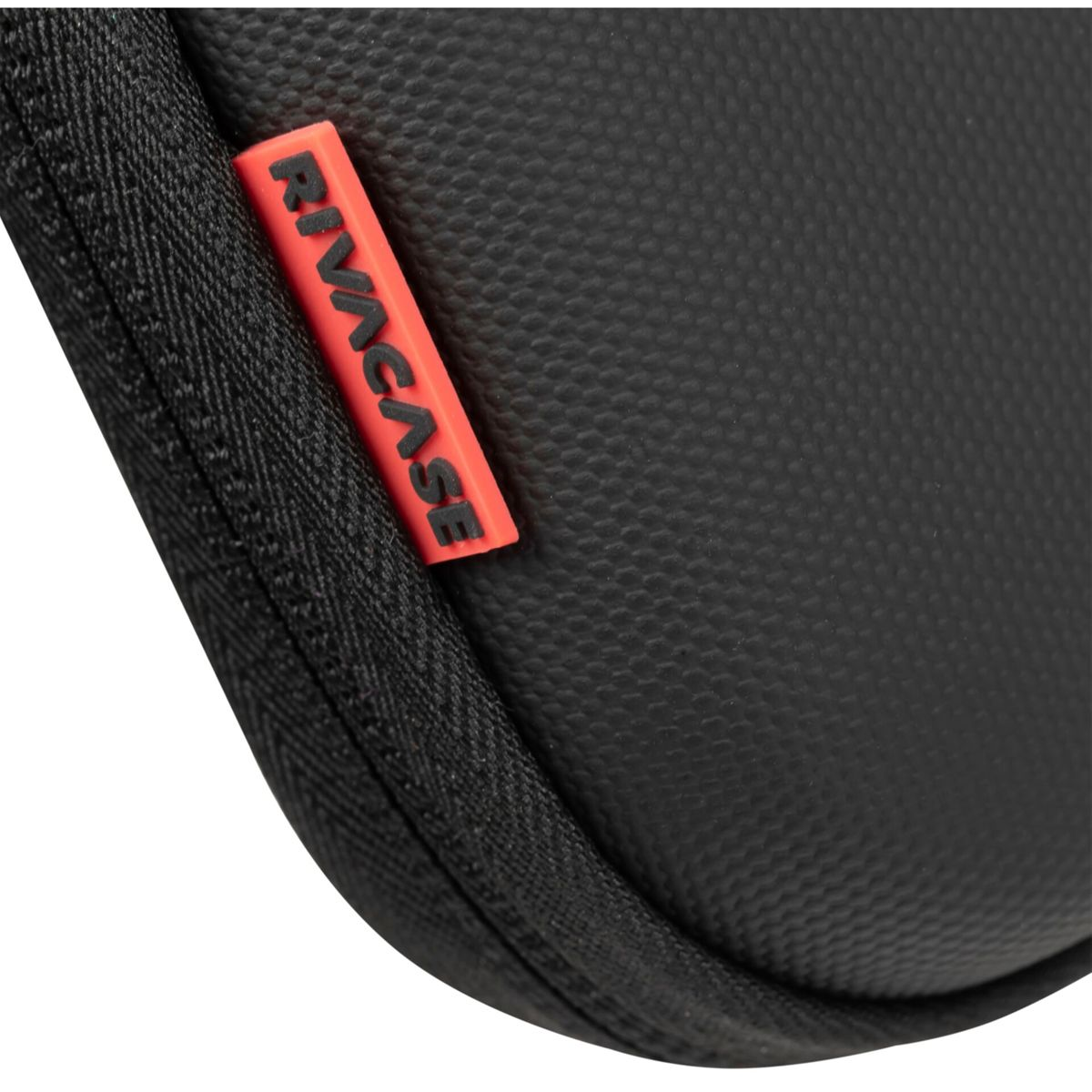 Czarna torba z czerwoną metką Rivacase. Widoczny zamek błyskawiczny. Zbliżenie. Czarne tło.