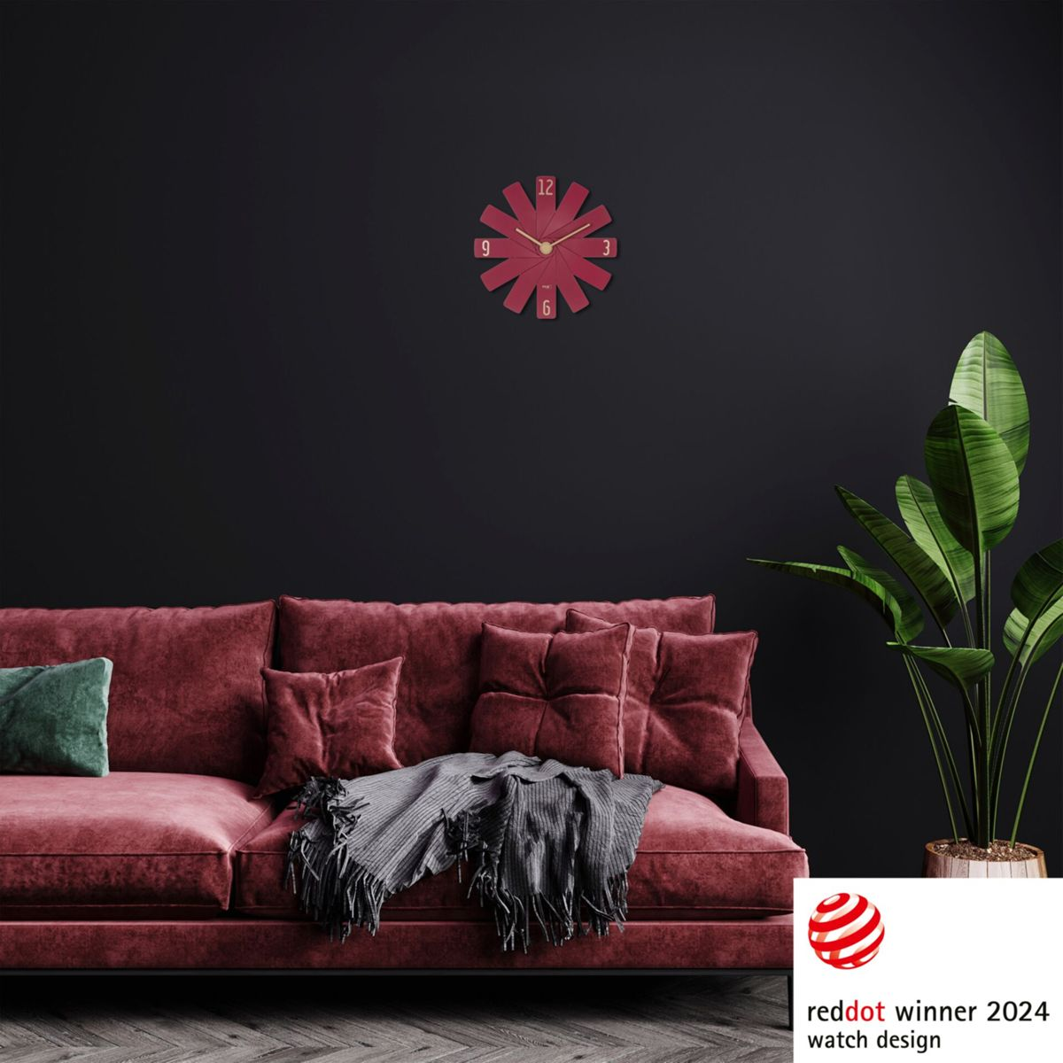 Eine rote Uhr an einer dunklen Wand. Die Uhr hat ein einzigartiges Sternenmuster. Ein Sofa und eine Pflanze sind zu sehen.