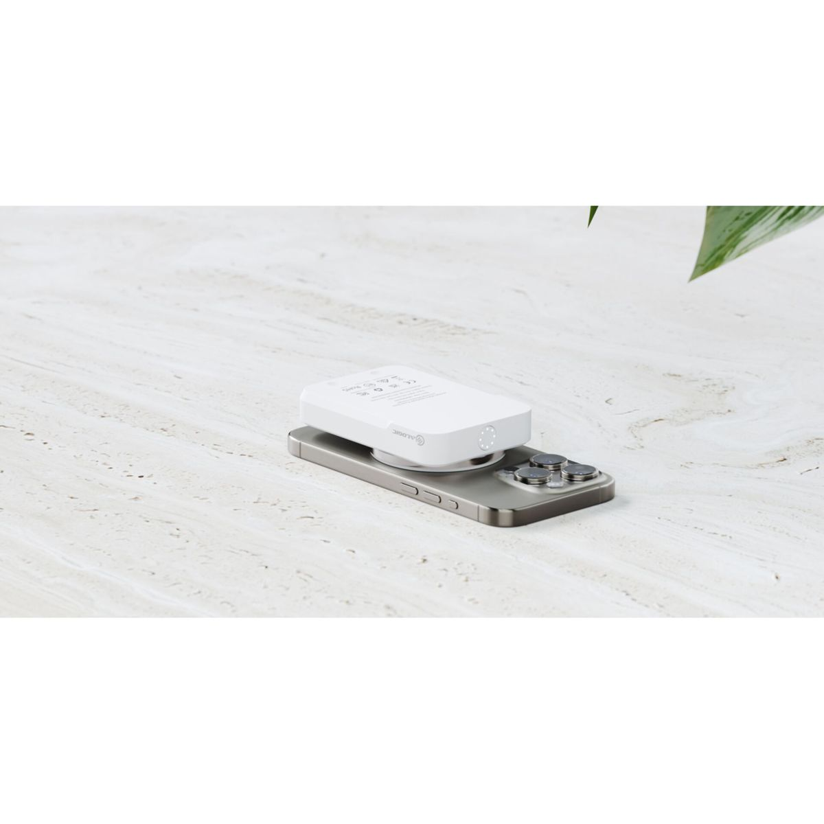 Un dispositivo bianco è posizionato sopra un telefono. Superficie in marmo come sfondo.