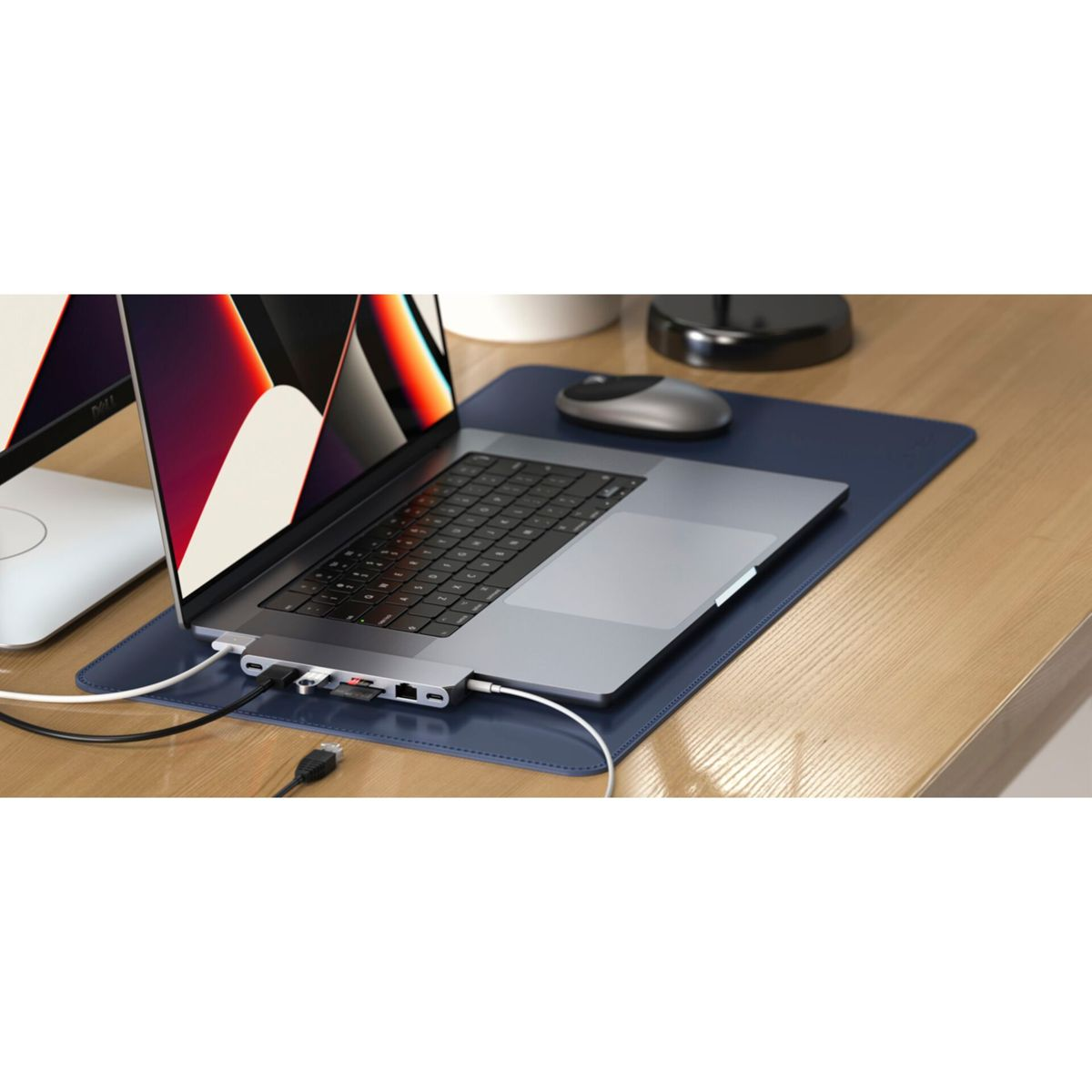 Laptop verbunden mit Hub, SD-Karte und Maus auf einem Schreibtisch mit blauer Matte. Der Laptop ist offen.