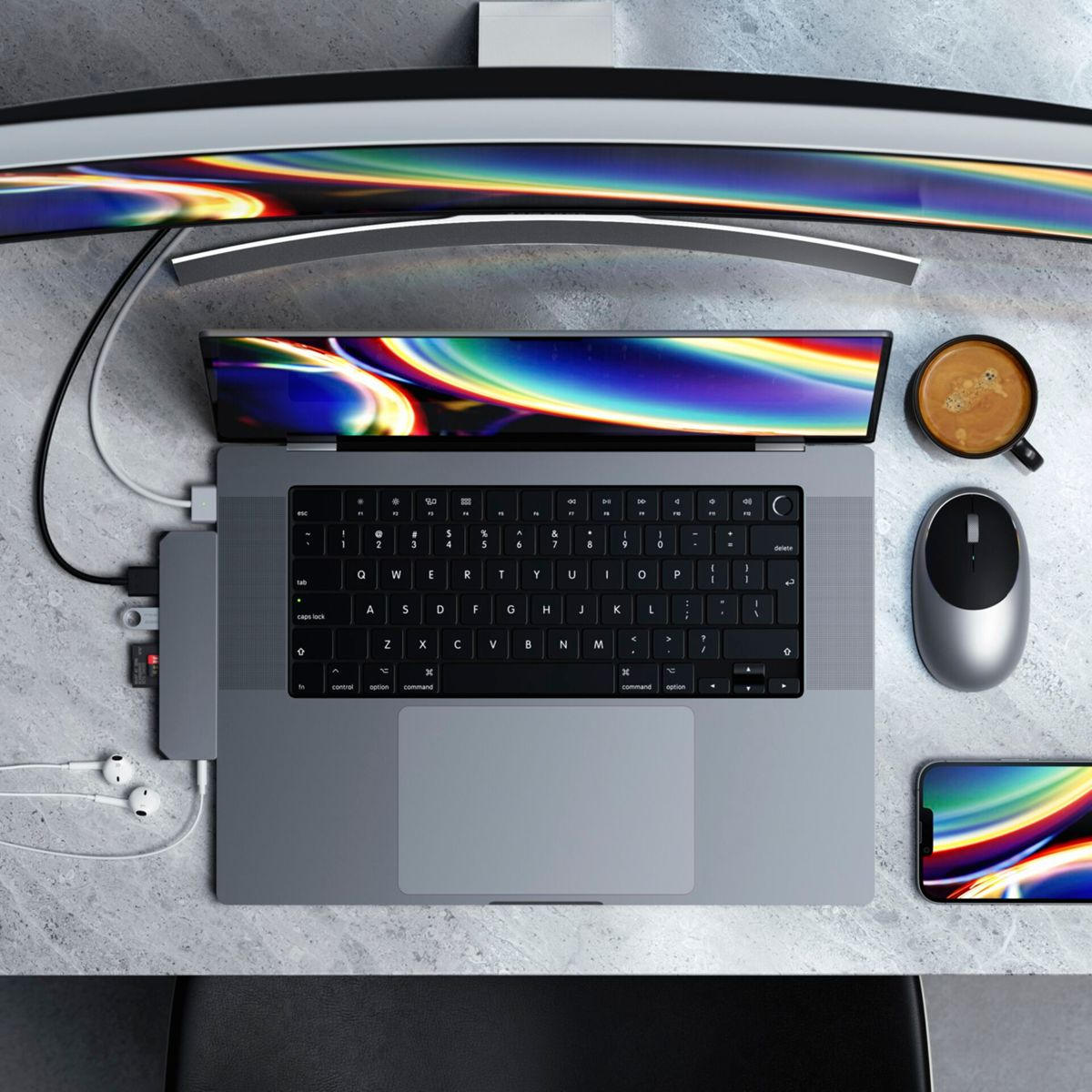 Laptop mit Hub, Maus und Telefon auf einem Tisch verbunden. Ein gebogener Monitor im Hintergrund.