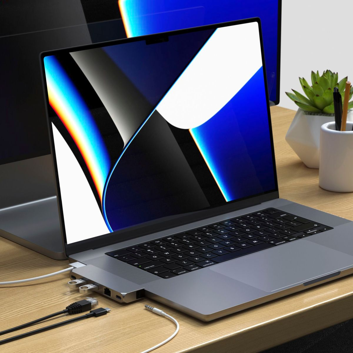 Laptop con un hub collegato lateralmente. L'hub ha porte USB e una porta Ethernet. Dispositivi aggiuntivi nelle vicinanze.