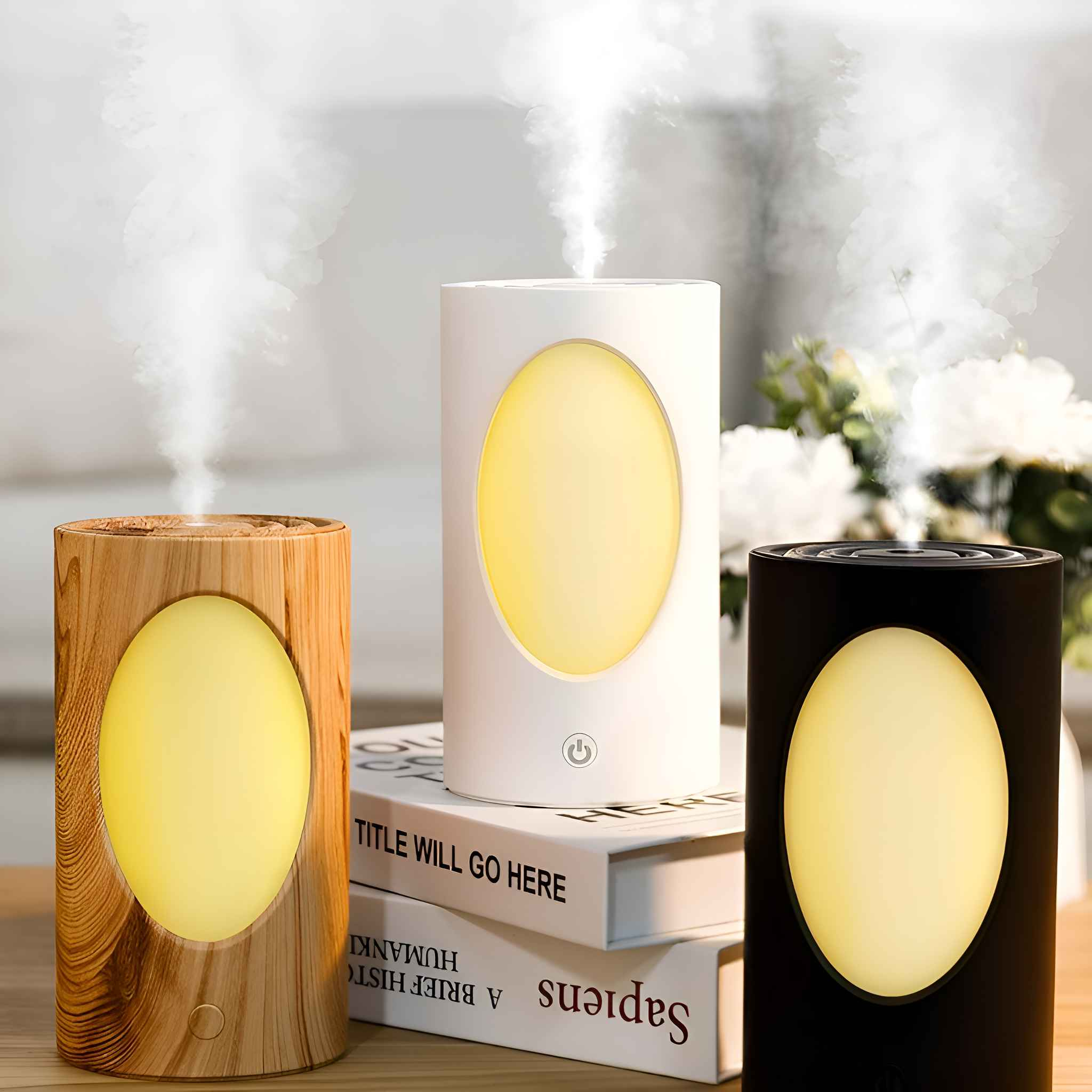 Drei Luftbefeuchter, Holz, Weiß und Schwarz, geben Nebel ab. Sie stehen auf Büchern. Dekorative Blumen sind in der Nähe.
