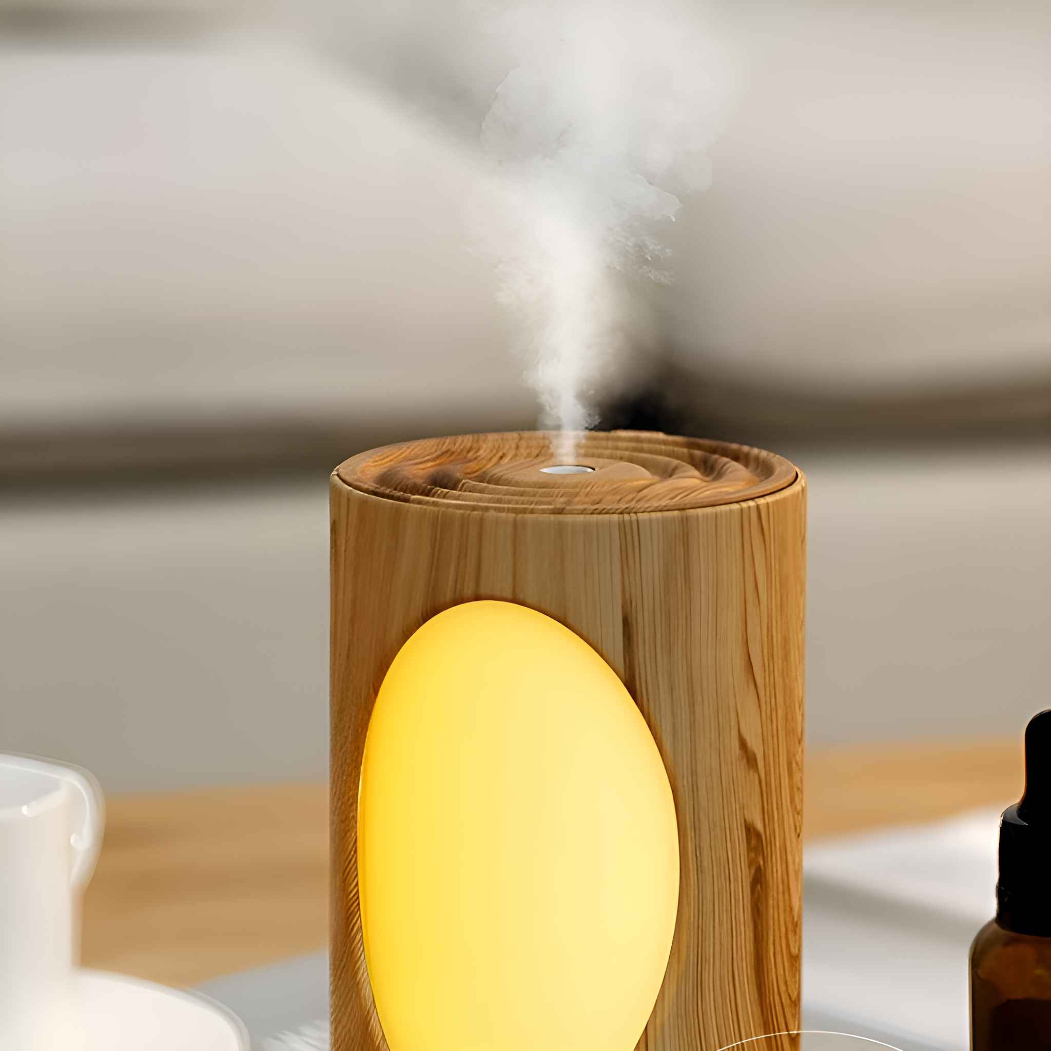 Ein Luftbefeuchter mit Holzmaserung und einem gelben ovalen Licht. Das Gerät gibt Dampf ab. Der Hintergrund ist unscharf.