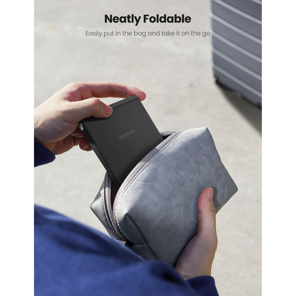 Czarna składana ładowarka jest umieszczana w szarej torbie. Tekst brzmi: Neatly Foldable.