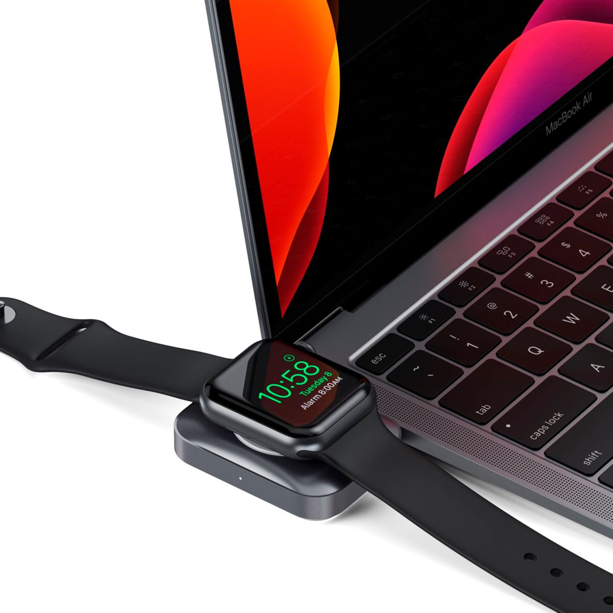 Apple Watch cargando en un portátil. El reloj muestra la hora y una correa negra.
