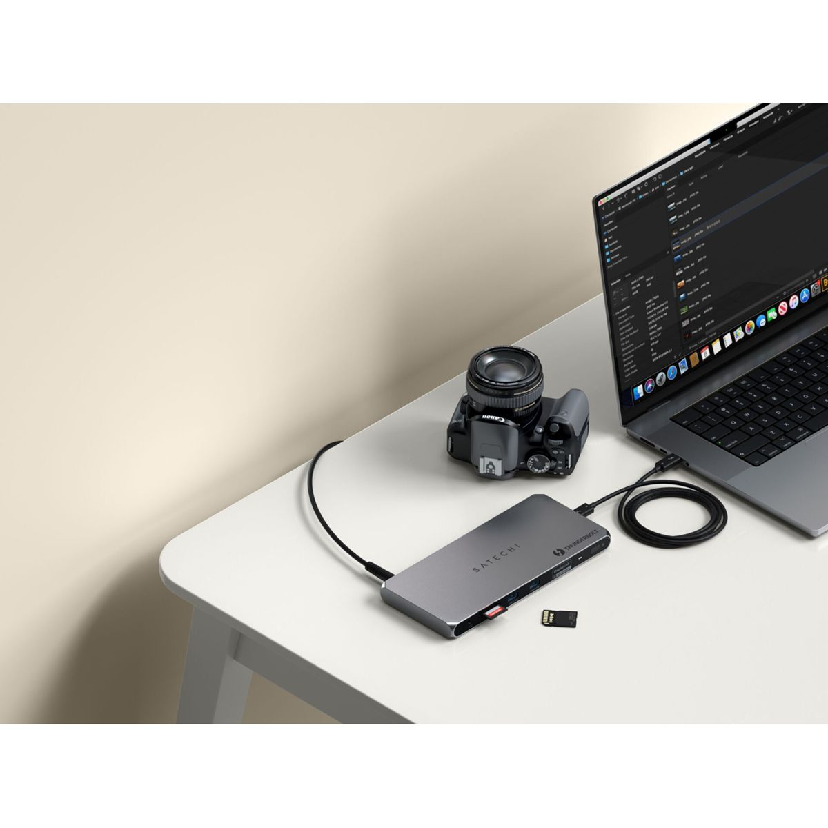 Eine Kamera, ein Hub, ein Laptop und eine Speicherkarte auf einem weißen Tisch.