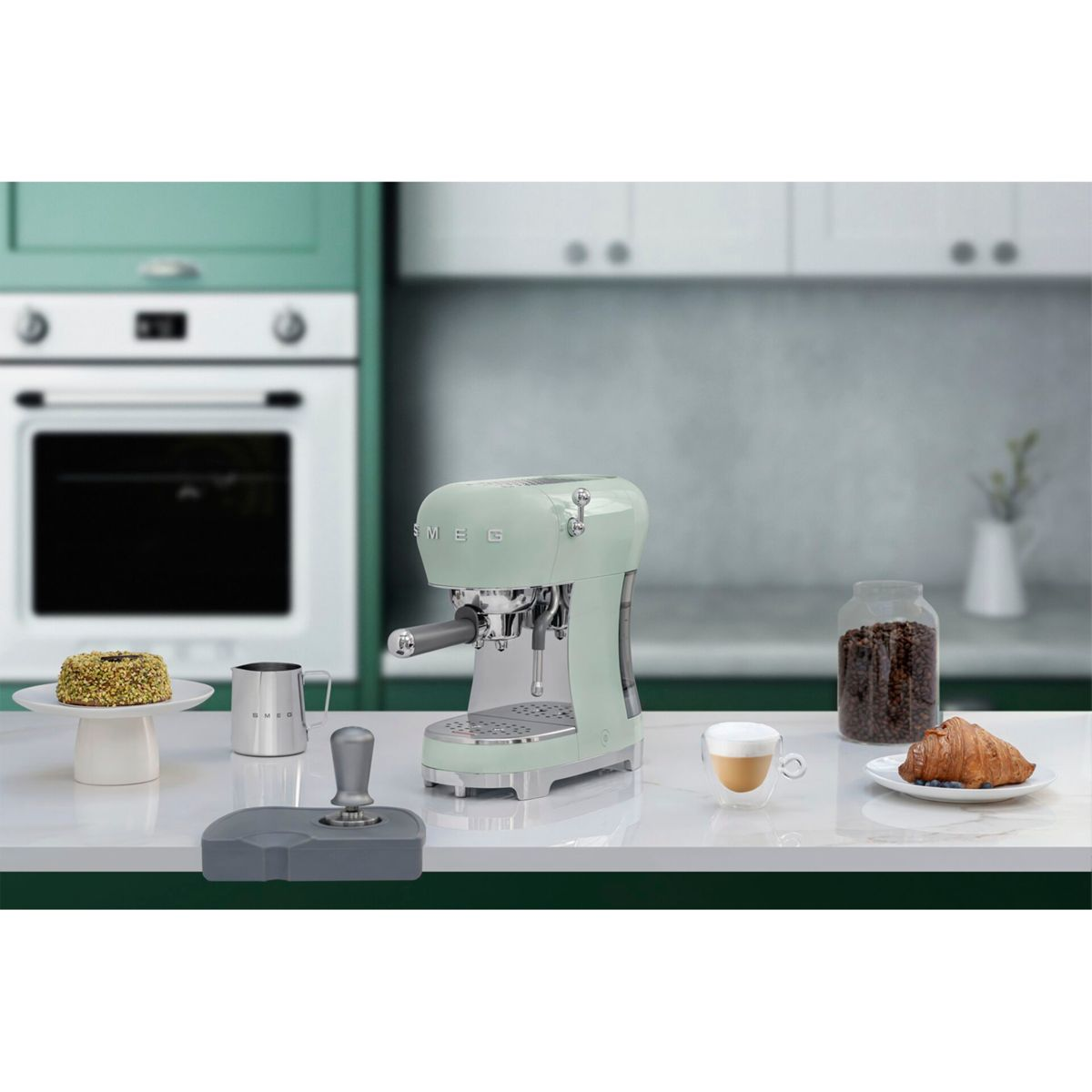 Una máquina de espresso verde menta en una encimera con café y pasteles.