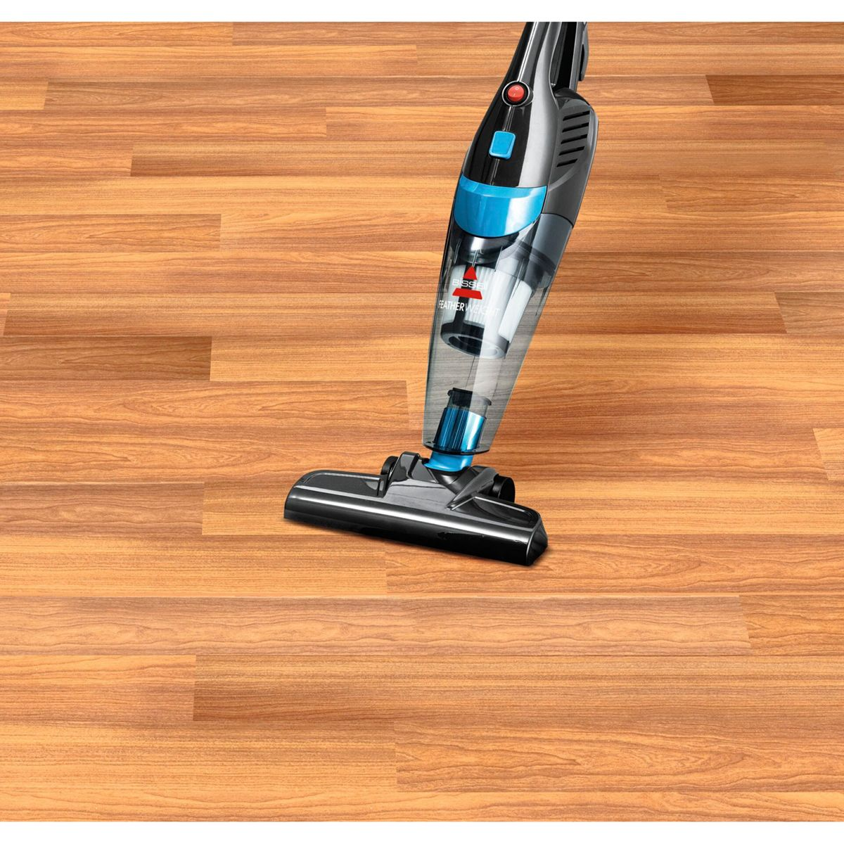 Ein schwarz-blauer Staubsauger auf einem Holzboden. Der Staubsauger wird verwendet, um den Boden zu reinigen. Der Boden ist aus Holz.