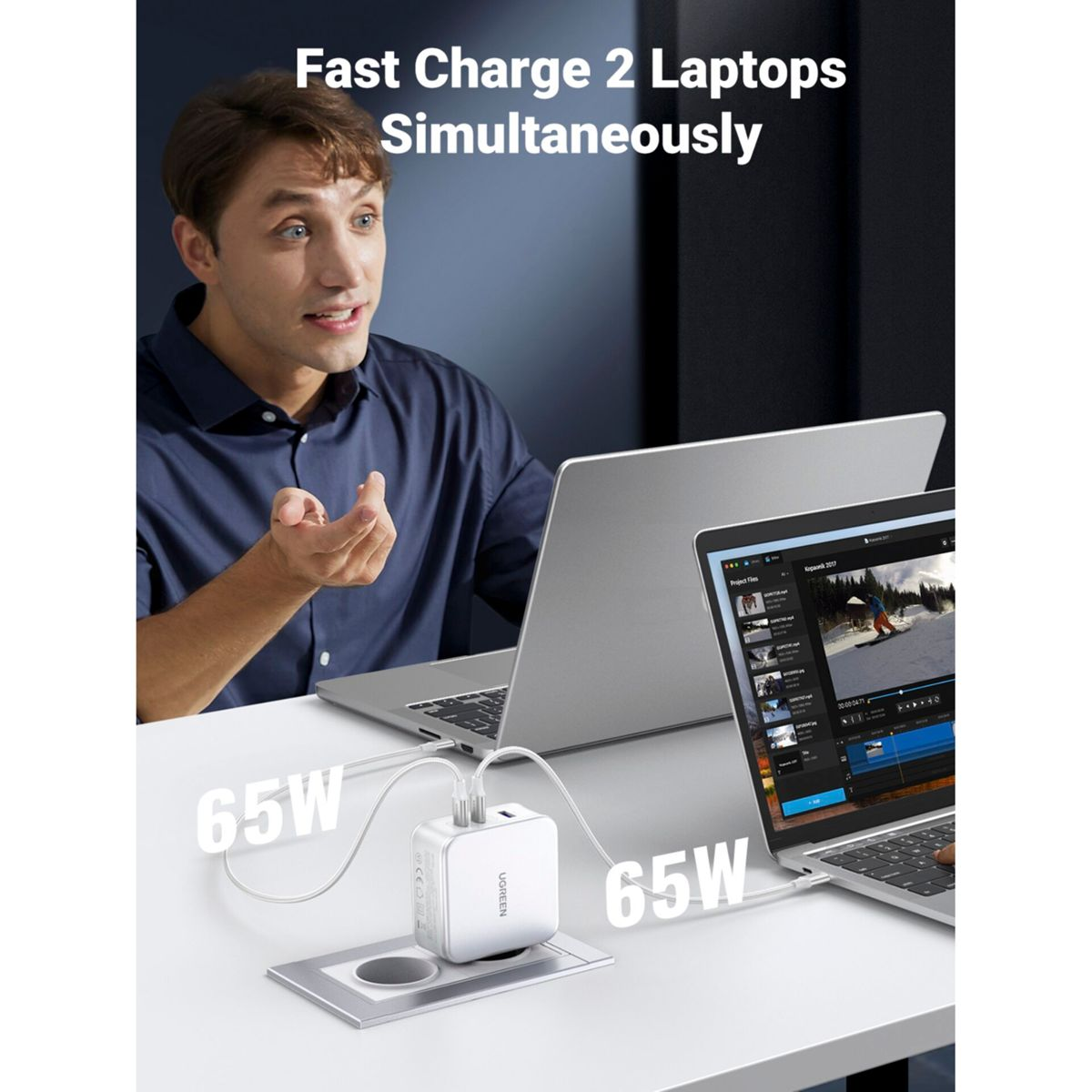 Un uomo guarda un laptop. Un caricatore bianco carica due laptop su una superficie bianca. Il testo è presente.