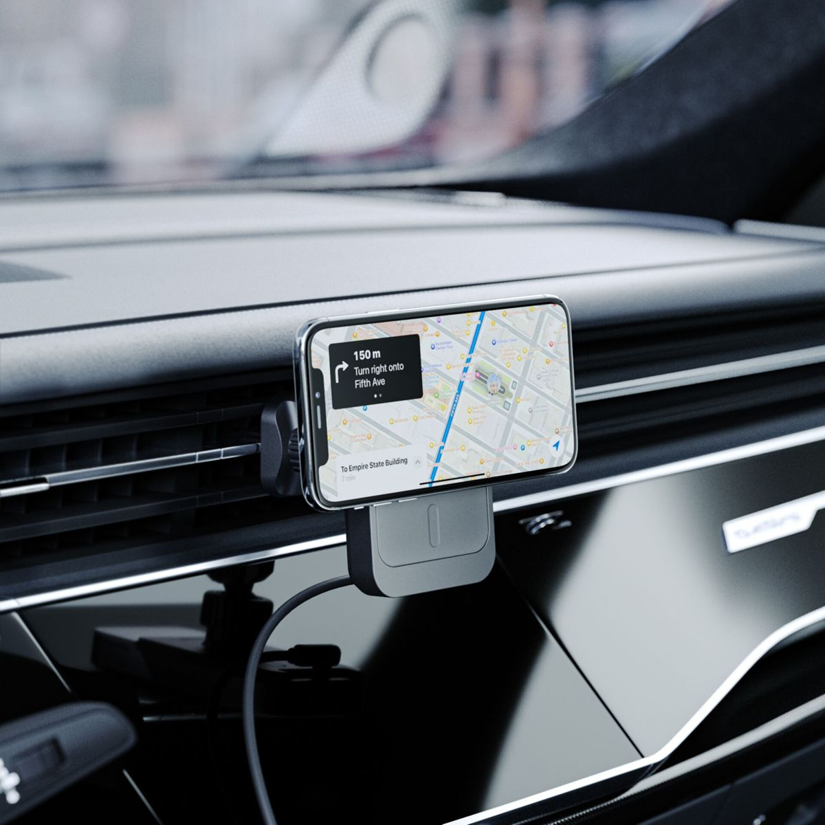 Telefon in Autohalterung, zeigt Navigations-App. Armaturenbrett sichtbar, mit unscharfem Hintergrund.