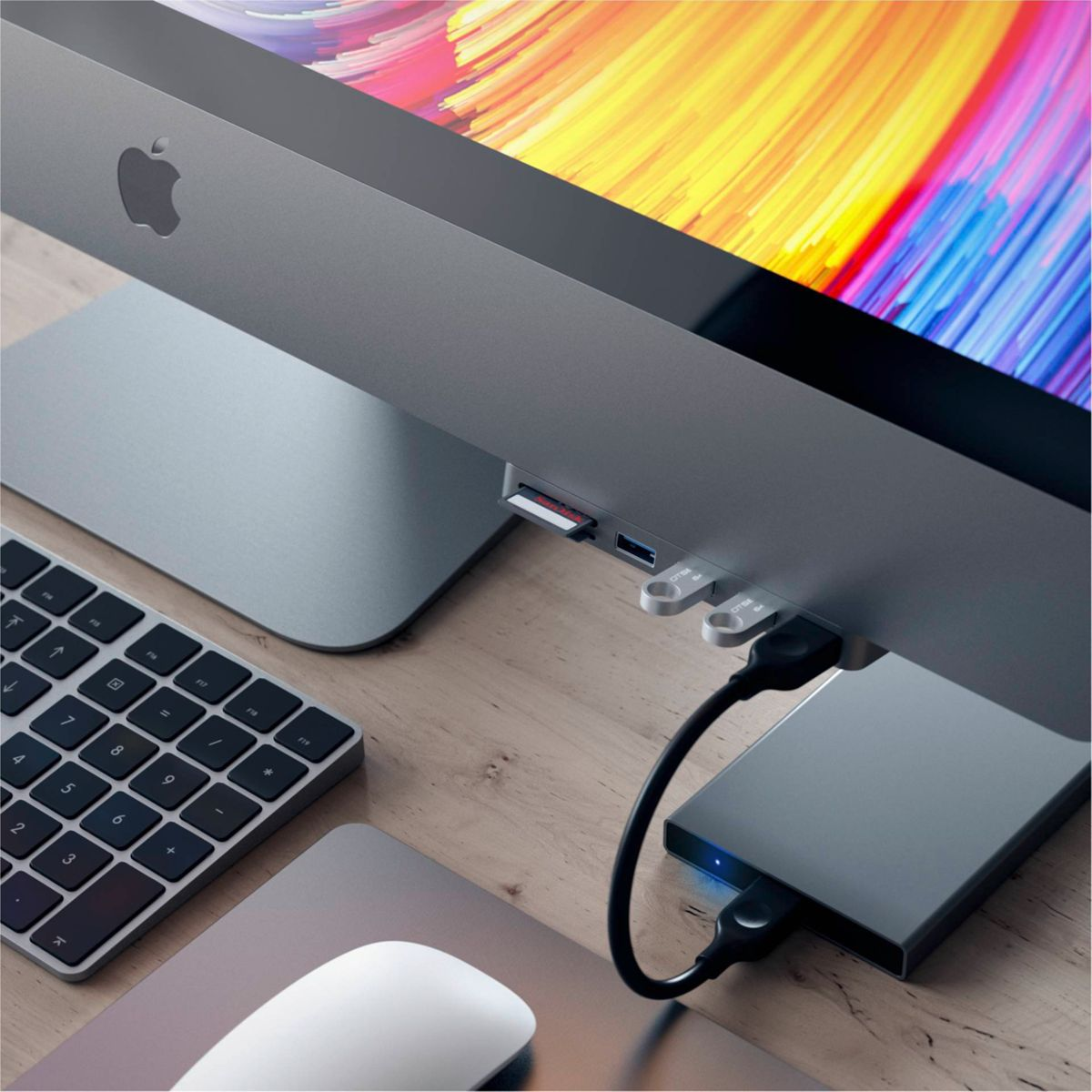 Apple-Monitor, Tastatur, Maus und Hub mit angeschlossener Festplatte.