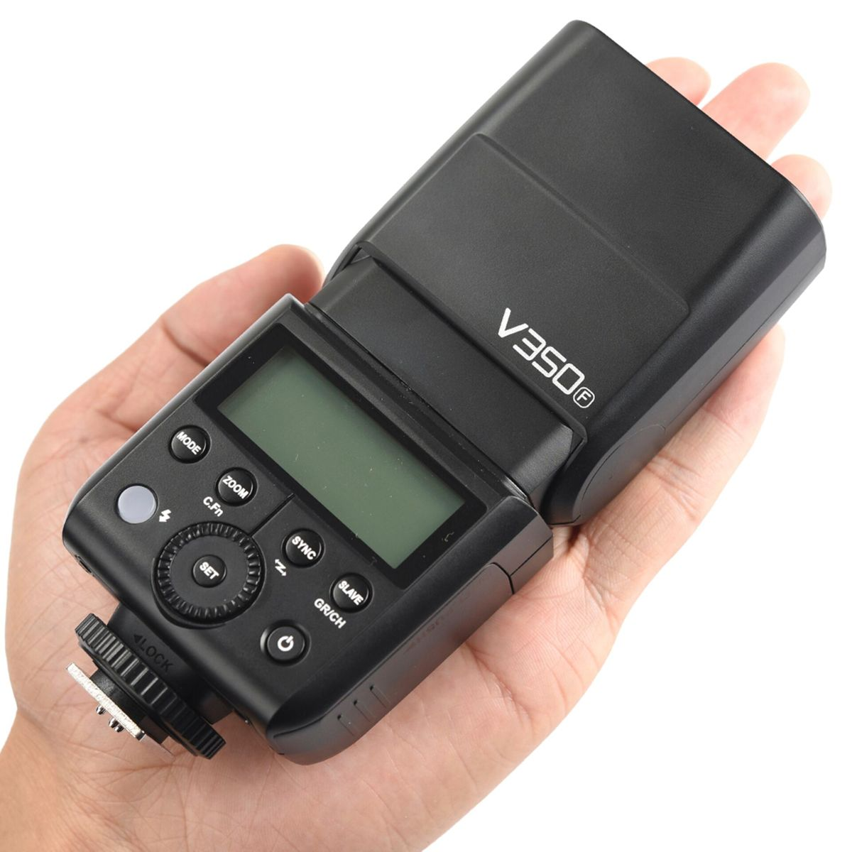 Un flash noir tenu dans une main. Il a des boutons et un écran. La marque est V350.