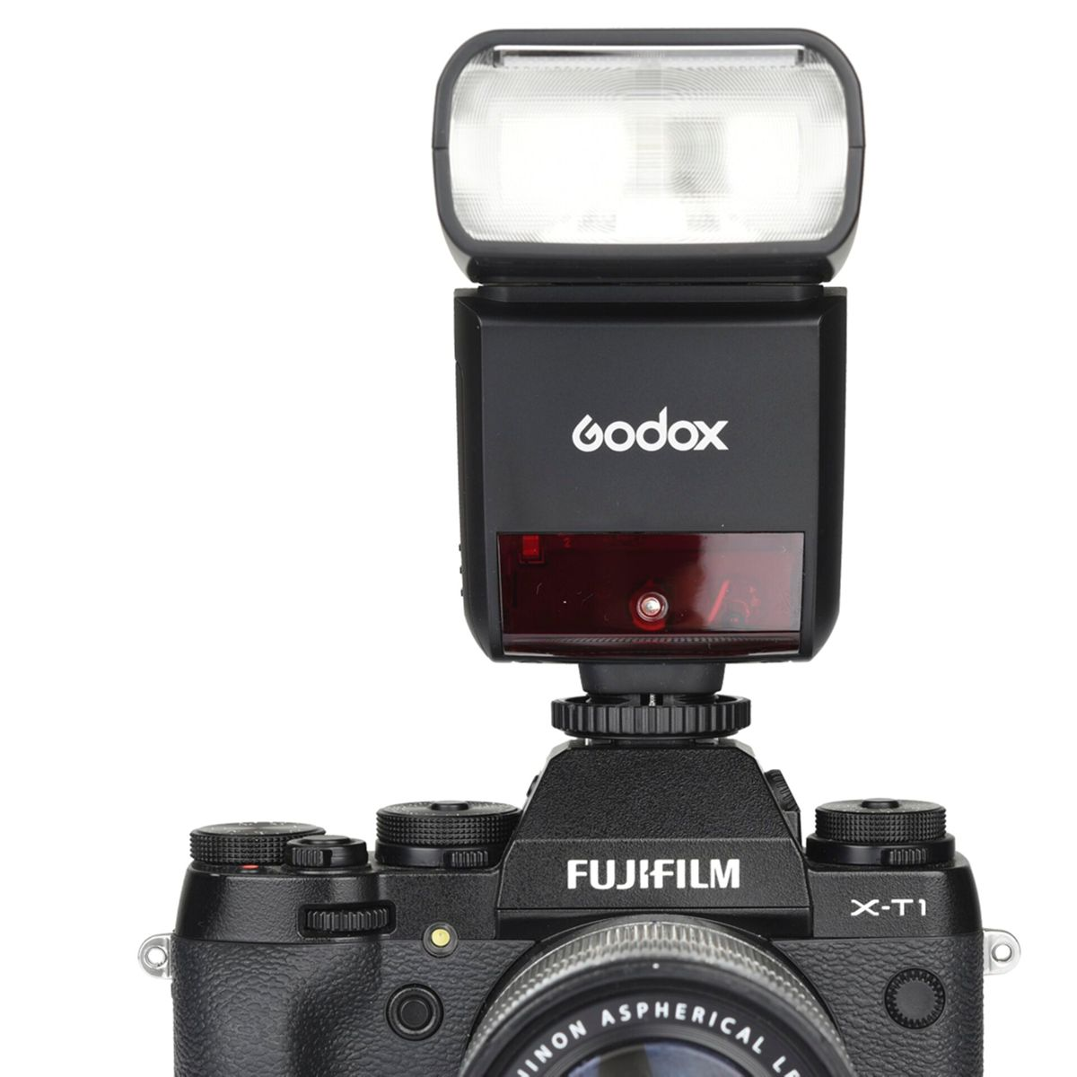 Un flash noir est monté sur un appareil photo. La marque est Godox. Le flash a un filtre rouge.