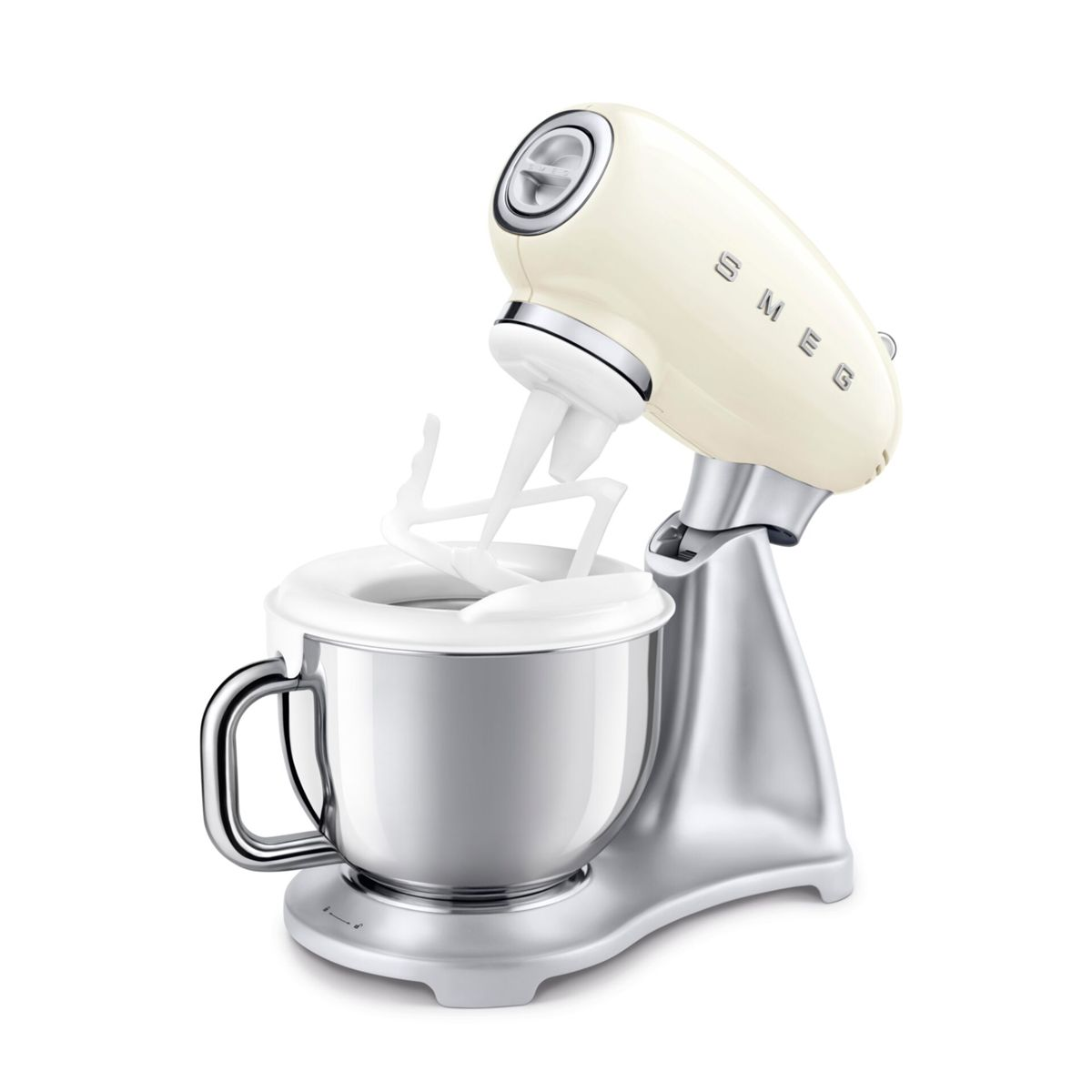 Un robot da cucina Smeg color crema con una ciotola di metallo e accessori, su una superficie bianca.