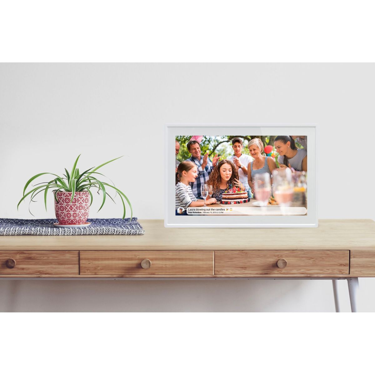Marco de fotos en mesa de madera mostrando una escena de cumpleaños.
