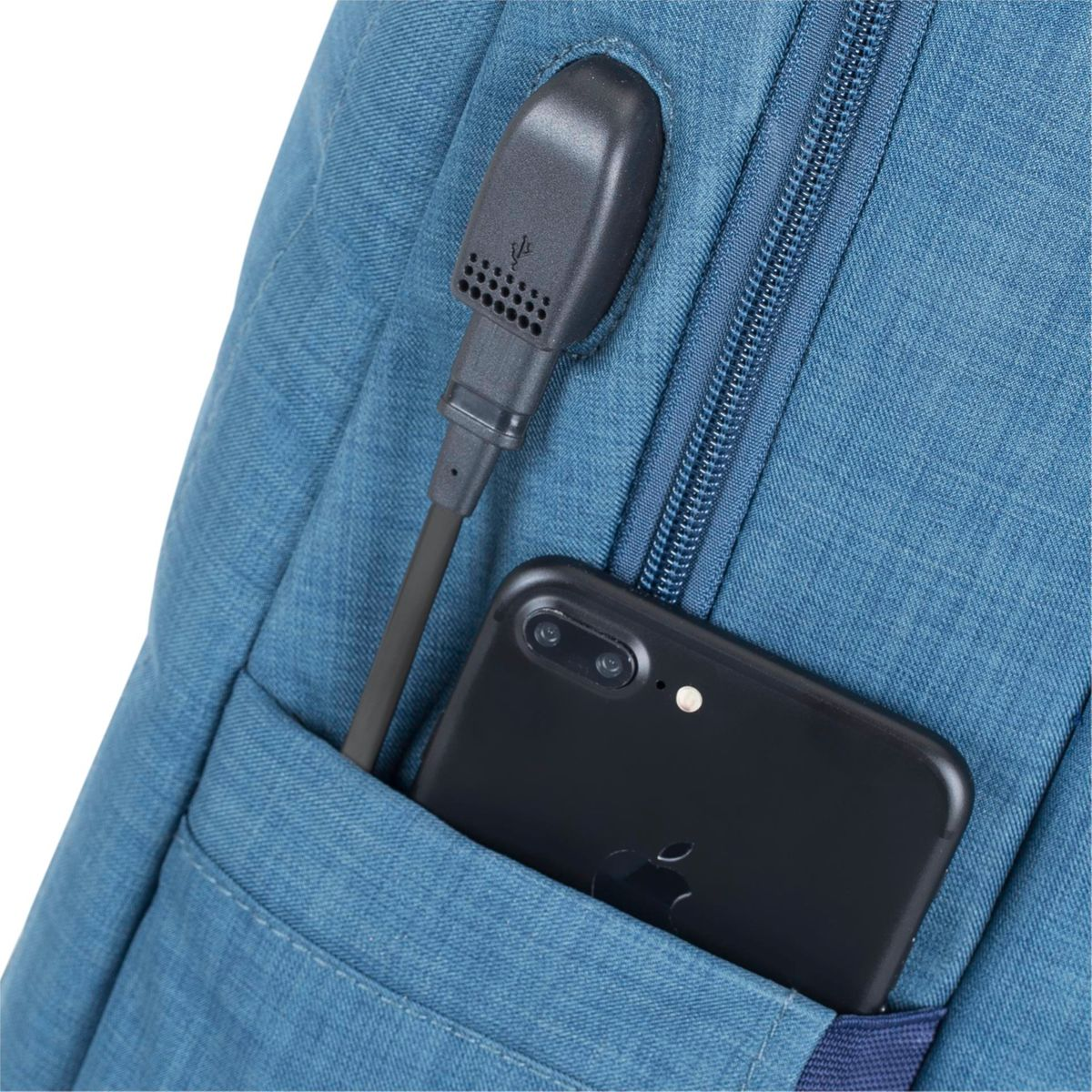 Nahaufnahme eines blauen Rucksacks. Ein schwarzes Telefon in einer Tasche und ein USB-Ladeanschluss mit Kabel. Isoliert auf Weiß.