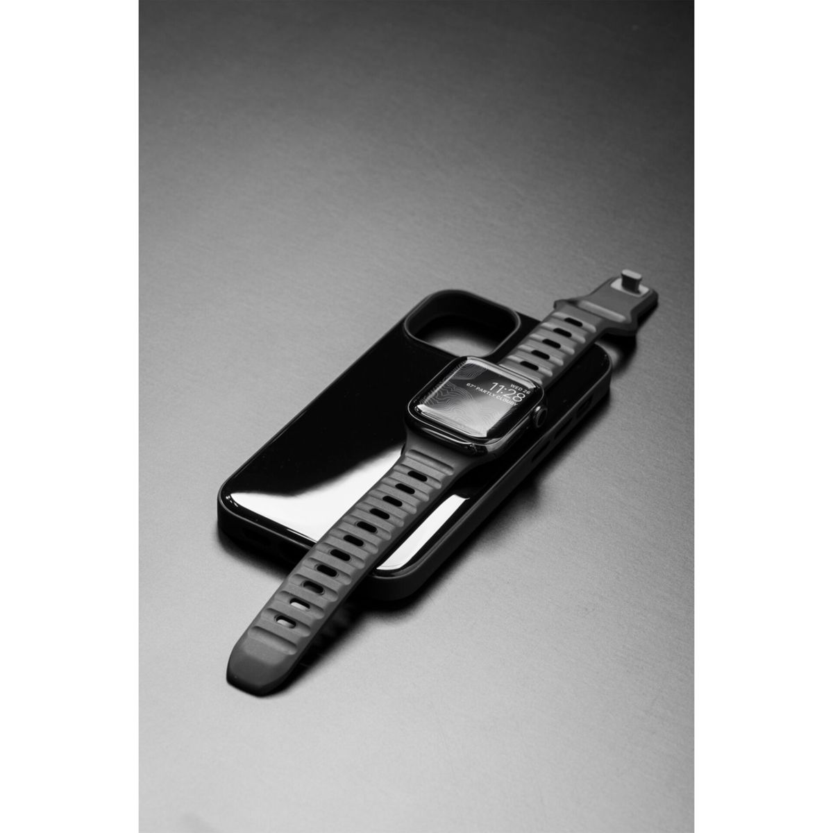 Schwarze Apple Watch auf schwarzer Handyhülle, auf schwarzer Oberfläche.