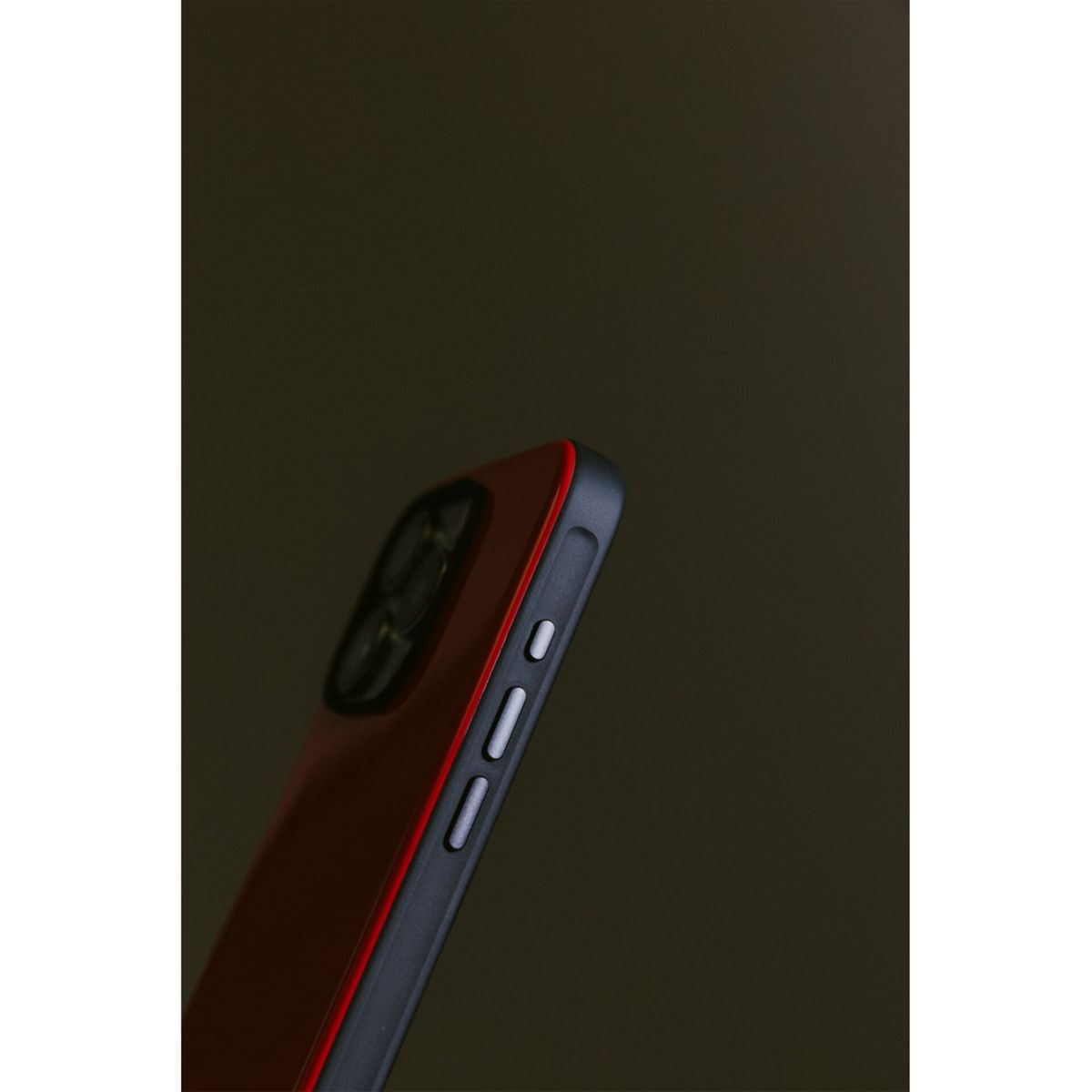 Un primo piano di una custodia per telefono rossa, che mostra il lato con i pulsanti e il rigonfiamento della fotocamera.
