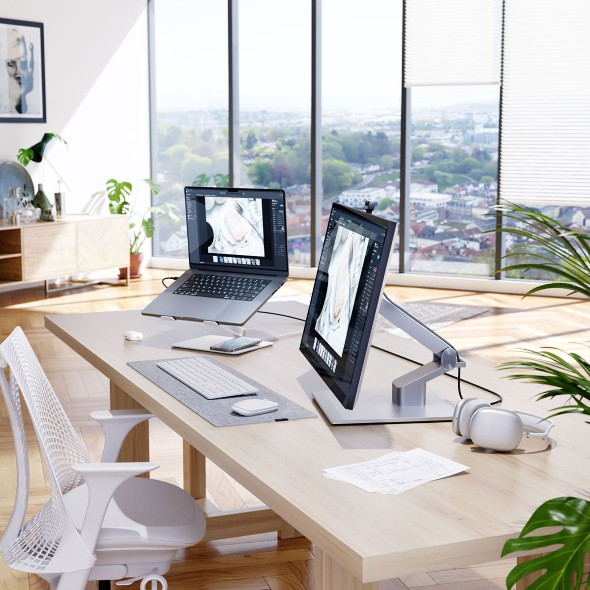 Un espace de bureau moderne comprend des ordinateurs portables, des écrans et une vue sur la ville.