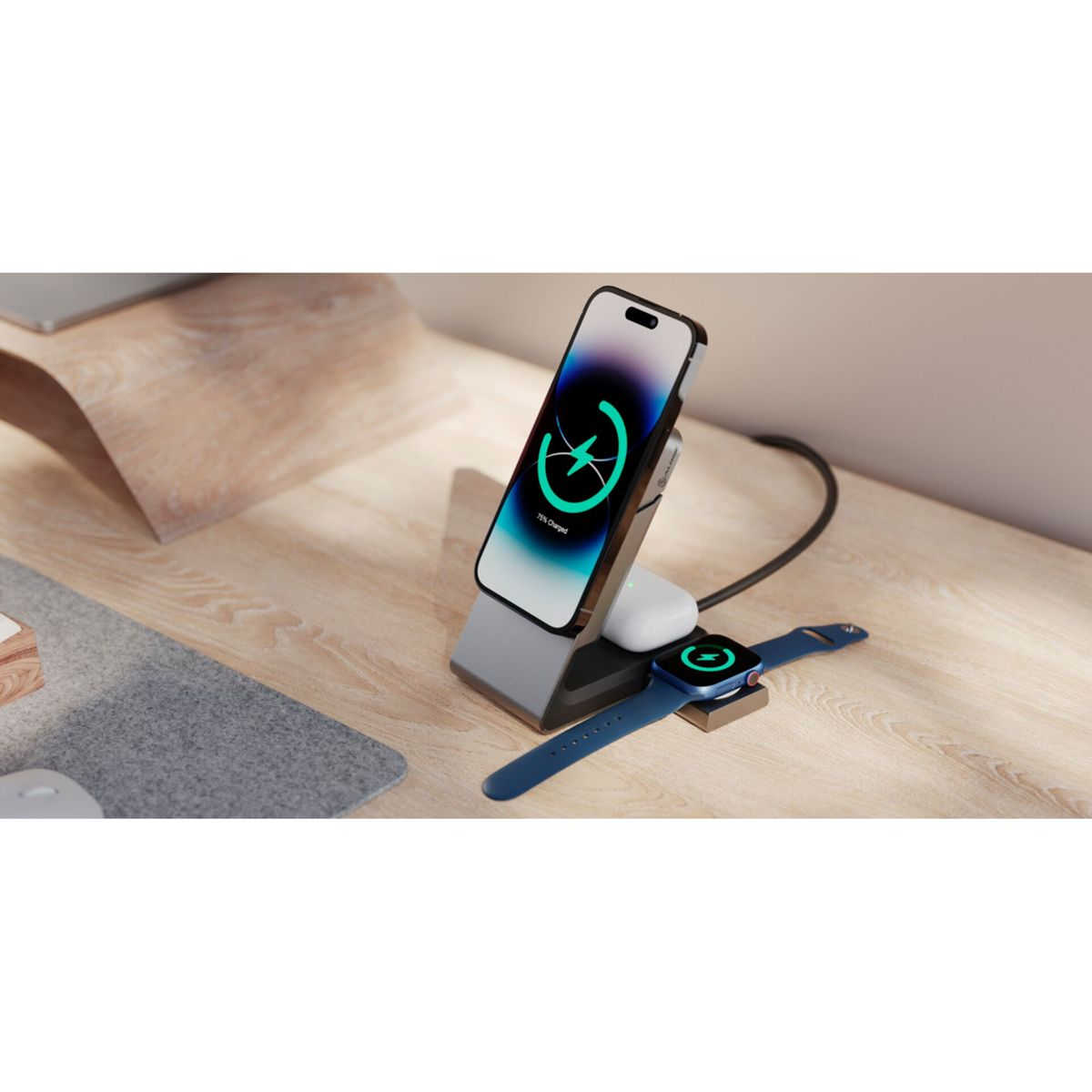 Una stazione di ricarica con telefono, auricolari e smartwatch su una scrivania in legno, tutti in carica.