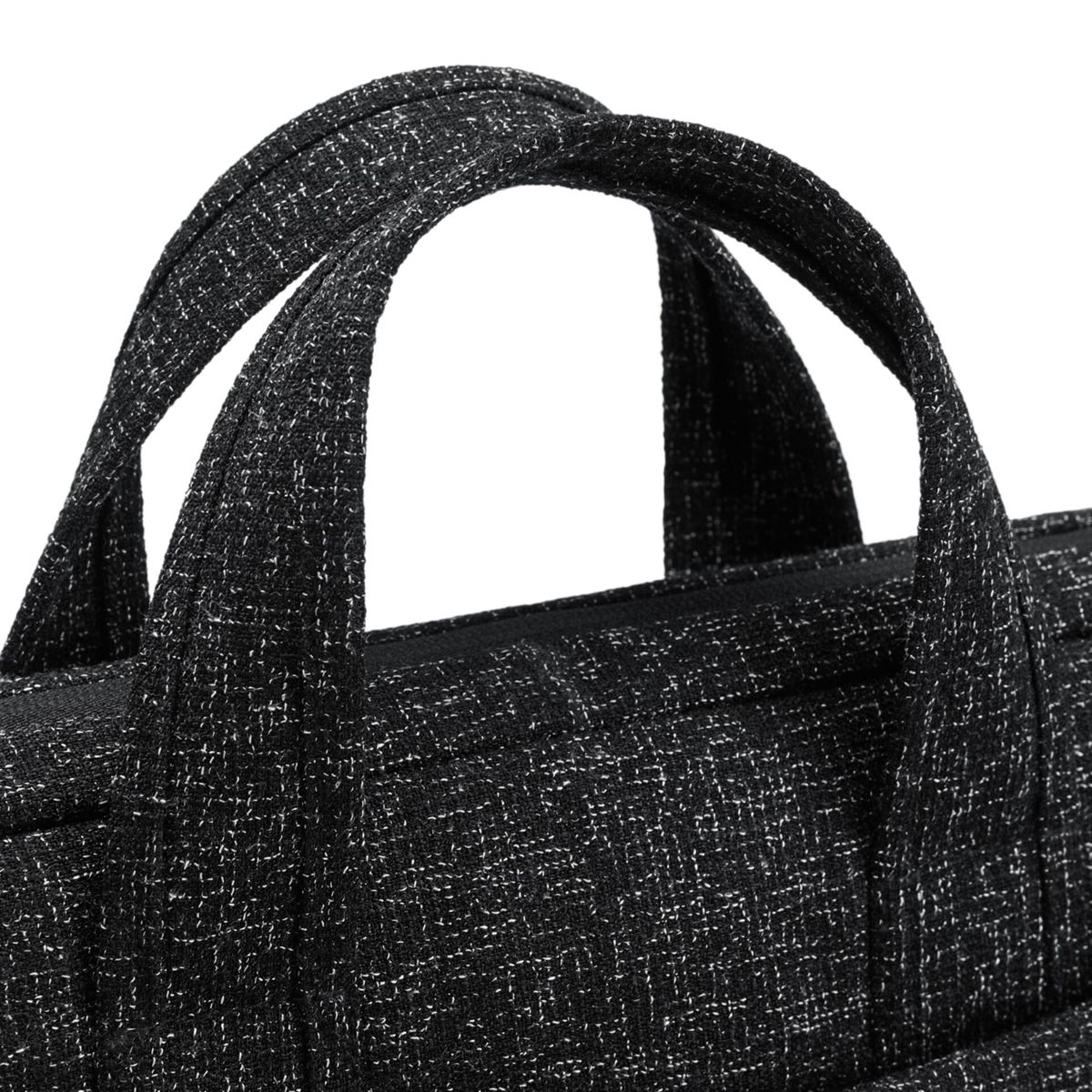 Nahaufnahme eines schwarz-weiß gemusterten Laptop-Taschengriffs, der die Stoffstruktur zeigt.