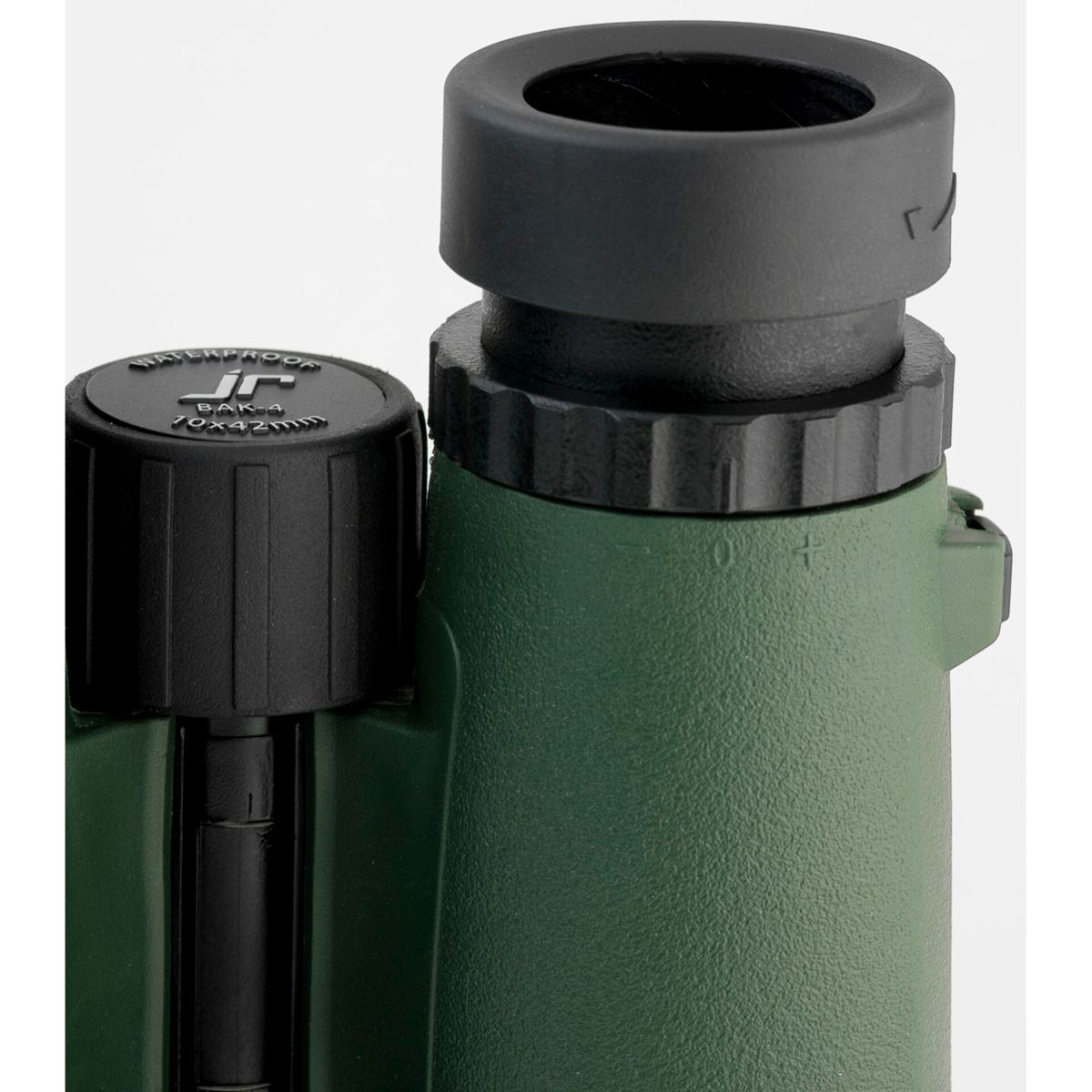 Zbliżenie zielonej lornetki, pokazujące obiektyw i czarne pokrętło regulacji.