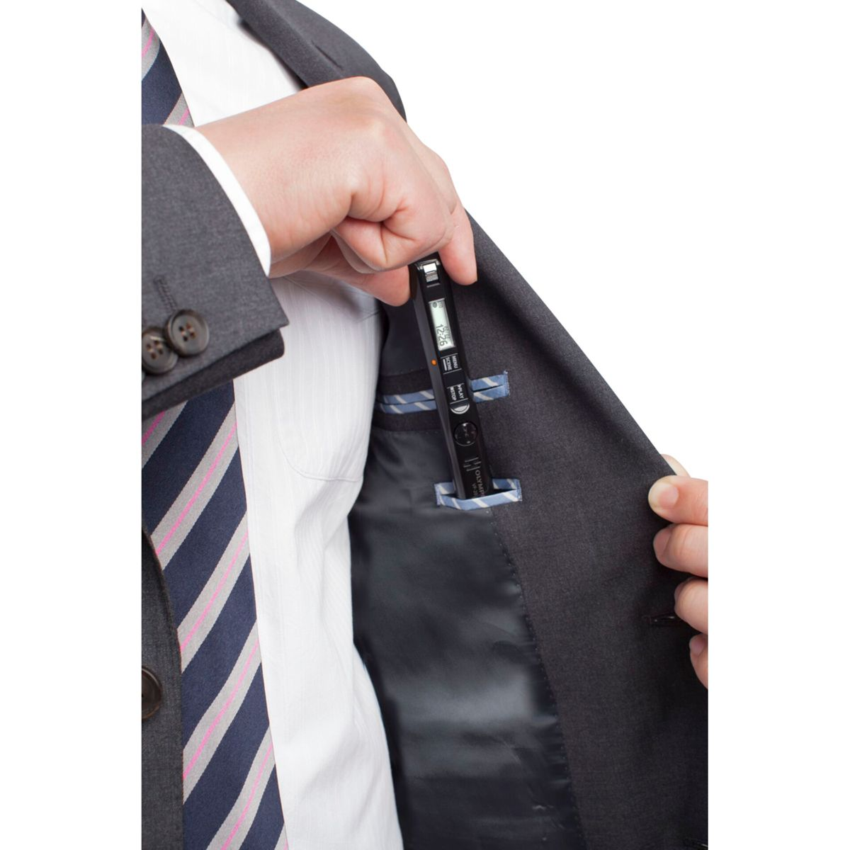 Osoba wkładająca czarny dyktafon Olympus do kieszeni marynarki.