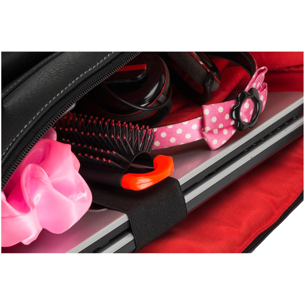 Un primo piano del contenuto di una borsa nera con interno rosso. Sono visibili un laptop e accessori.