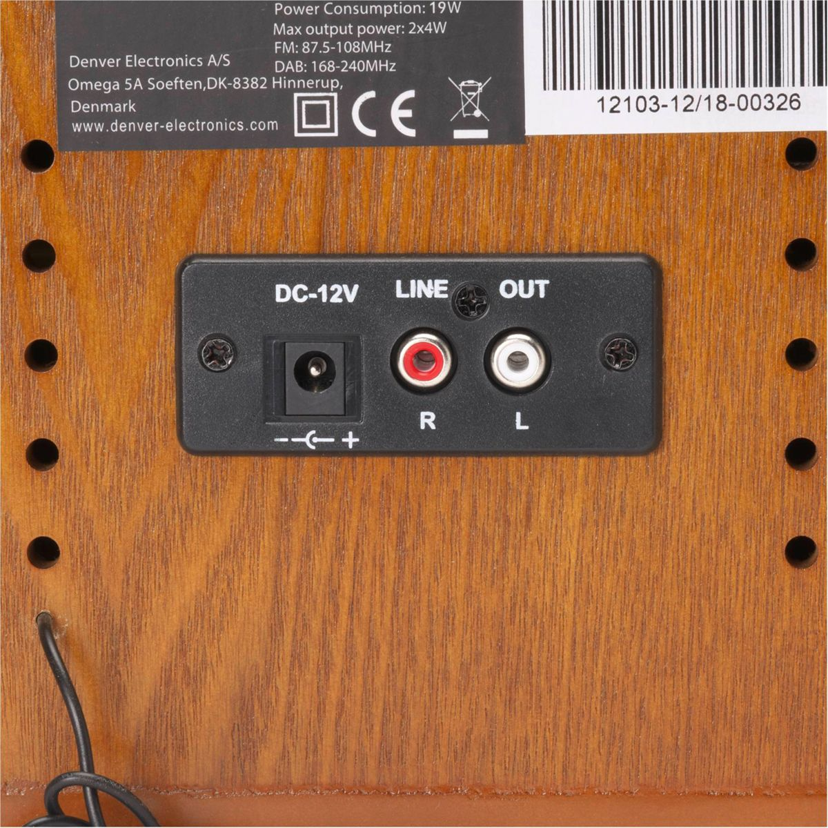 De achterkant van een houten retro radio met labels en ingangen wordt getoond. Het heeft connectoren en een barcode sticker.
