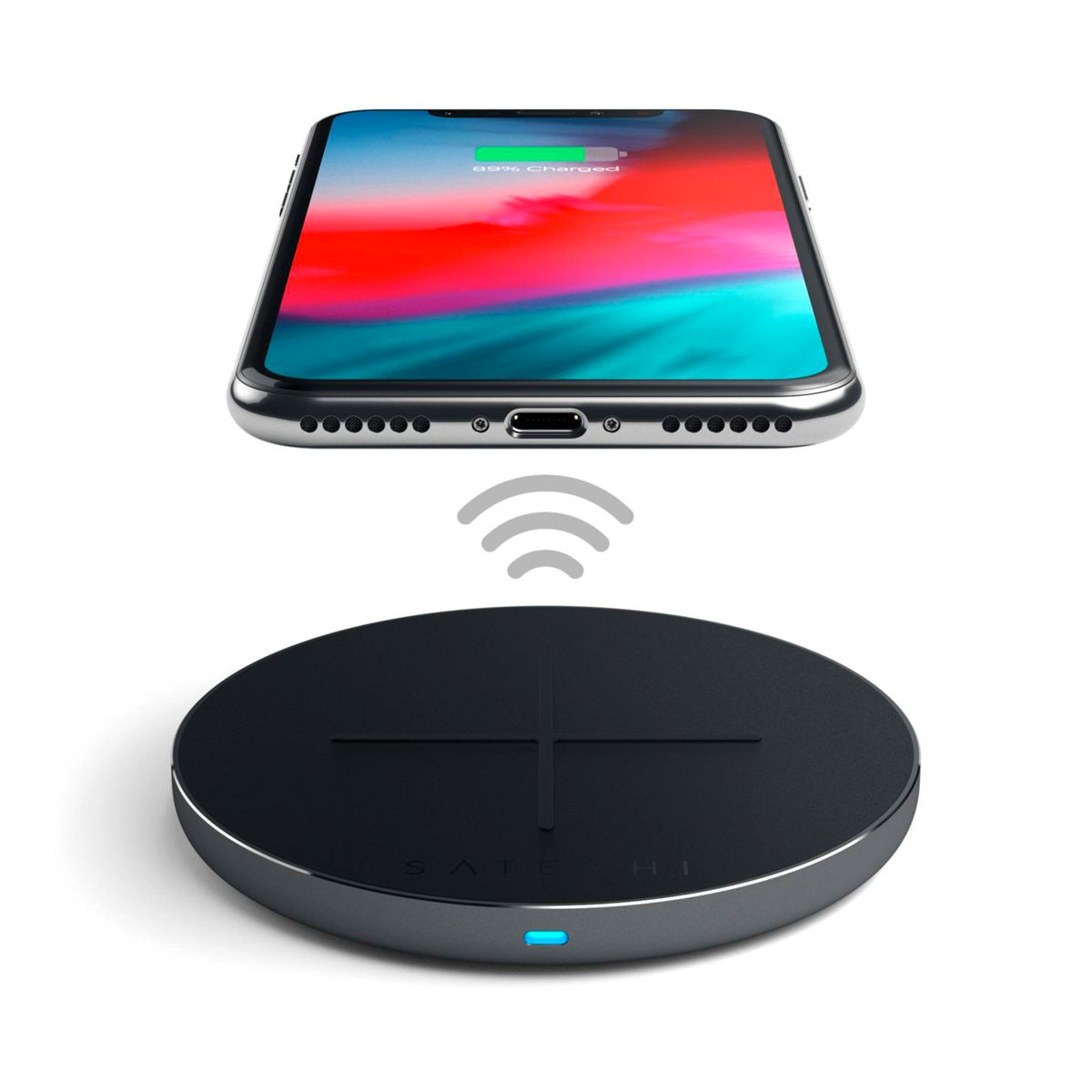 Een smartphone ligt op een draadloze oplader. De telefoon toont een oplaadpictogram en de oplader is zwart.