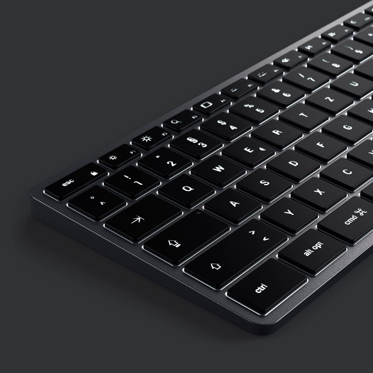 Eine dunkle Tastatur mit schwarzen Tasten und weißen, beleuchteten Zeichen. Die Tastatur liegt auf dunkler Oberfläche.