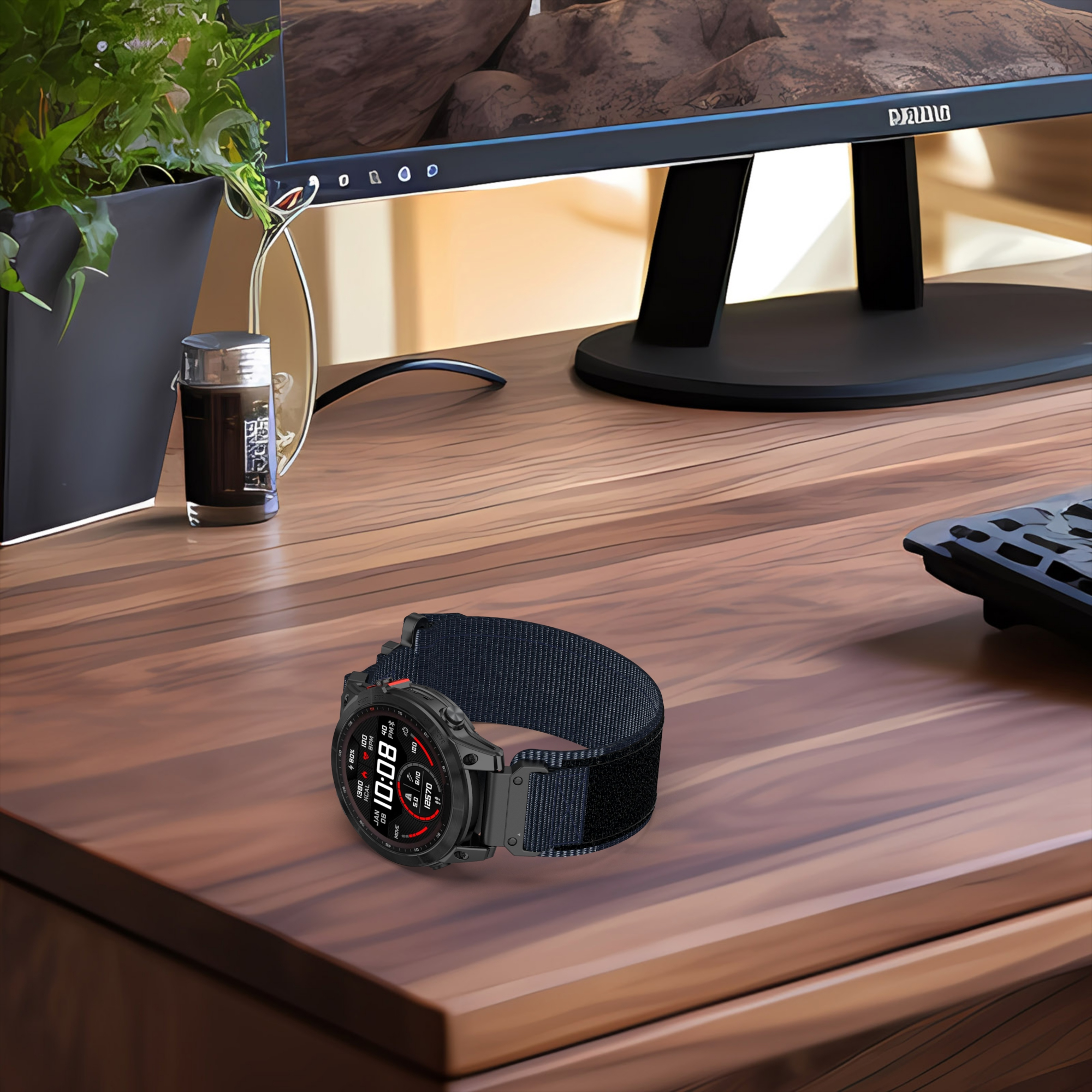 Czarny smartwatch z czarnym paskiem na drewnianym biurku. Widoczny jest monitor, roślina i inne przedmioty.