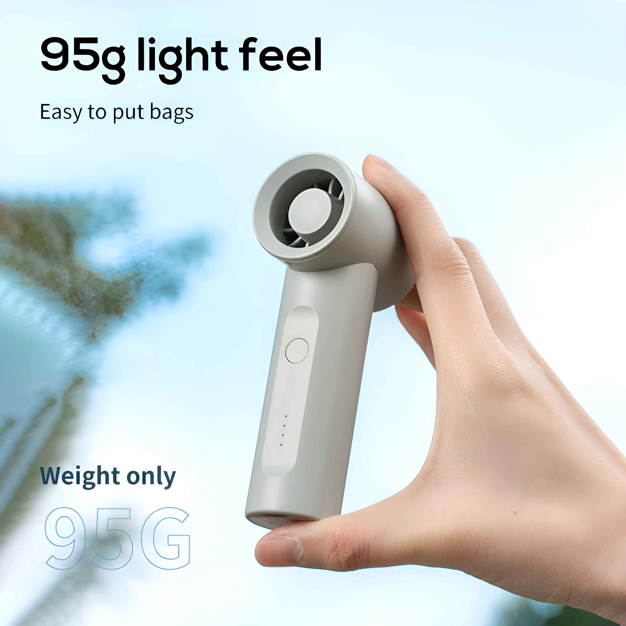 Ein kleiner, grauer Handventilator, der von einer Hand gehalten wird. Text zeigt, dass das Gewicht 95 g beträgt.