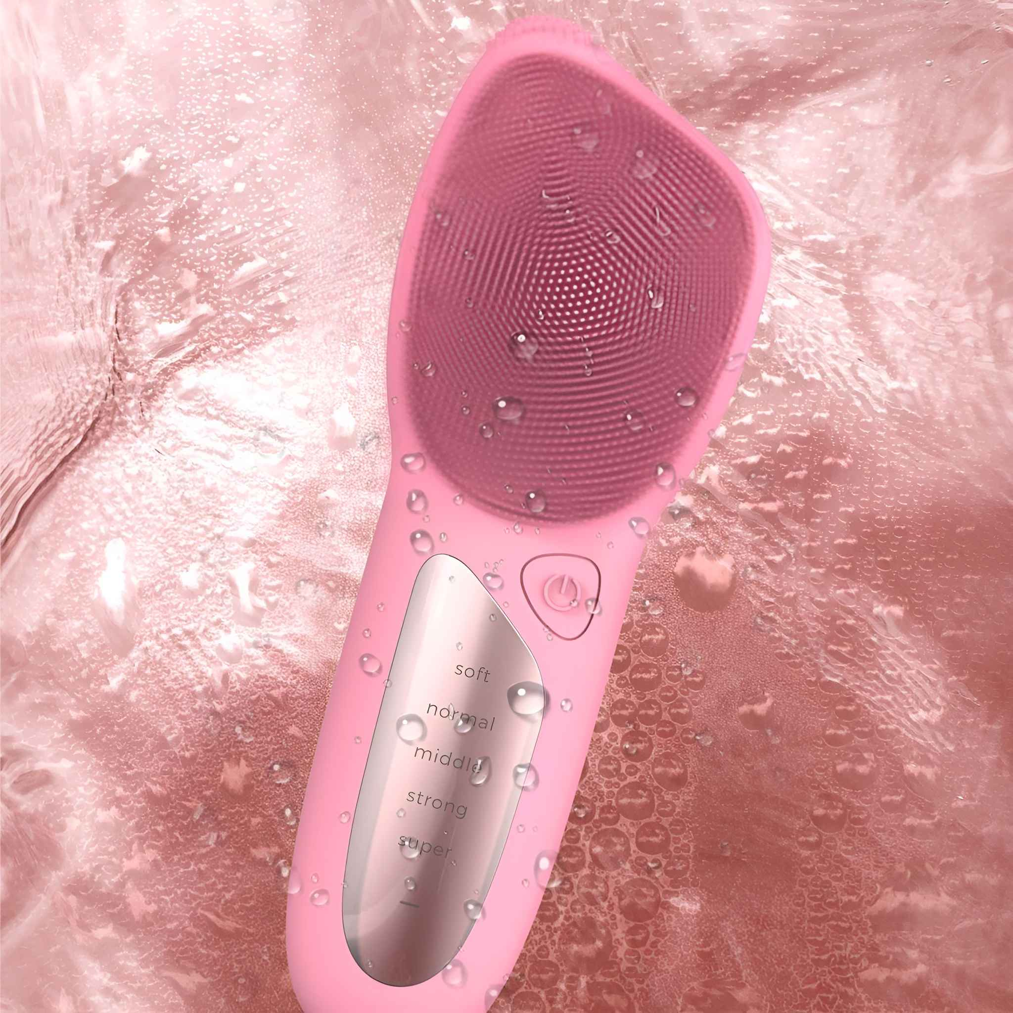 Eine rosa Gesichtsbürste mit strukturierter Oberfläche, bedeckt mit Wassertropfen, auf rosa Hintergrund.