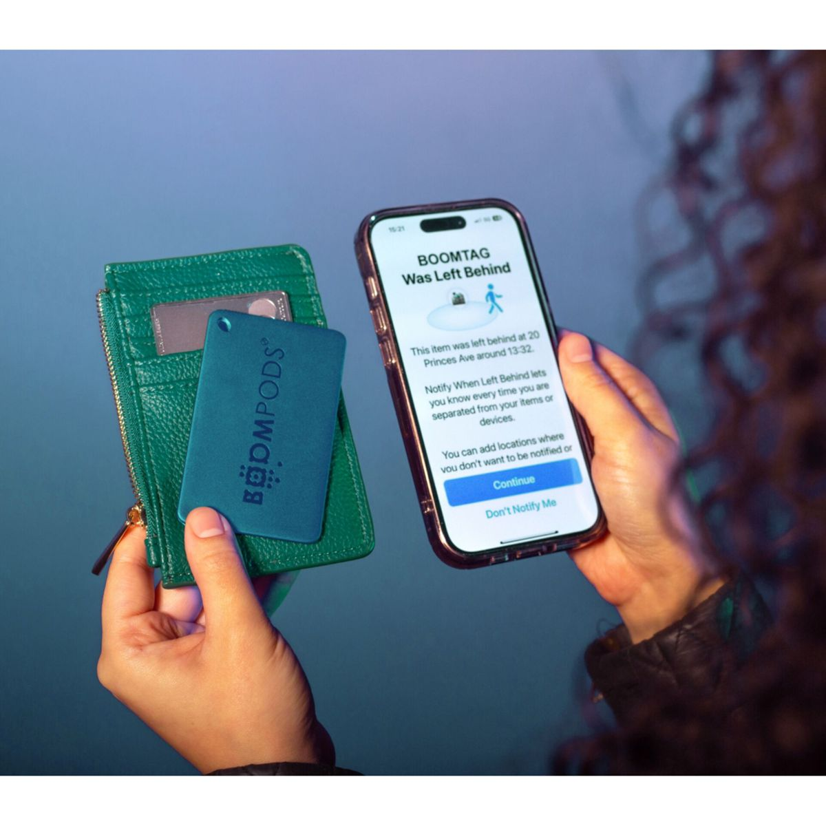 Ręce trzymają portfel, znacznik i telefon. Telefon wyświetla powiadomienie.