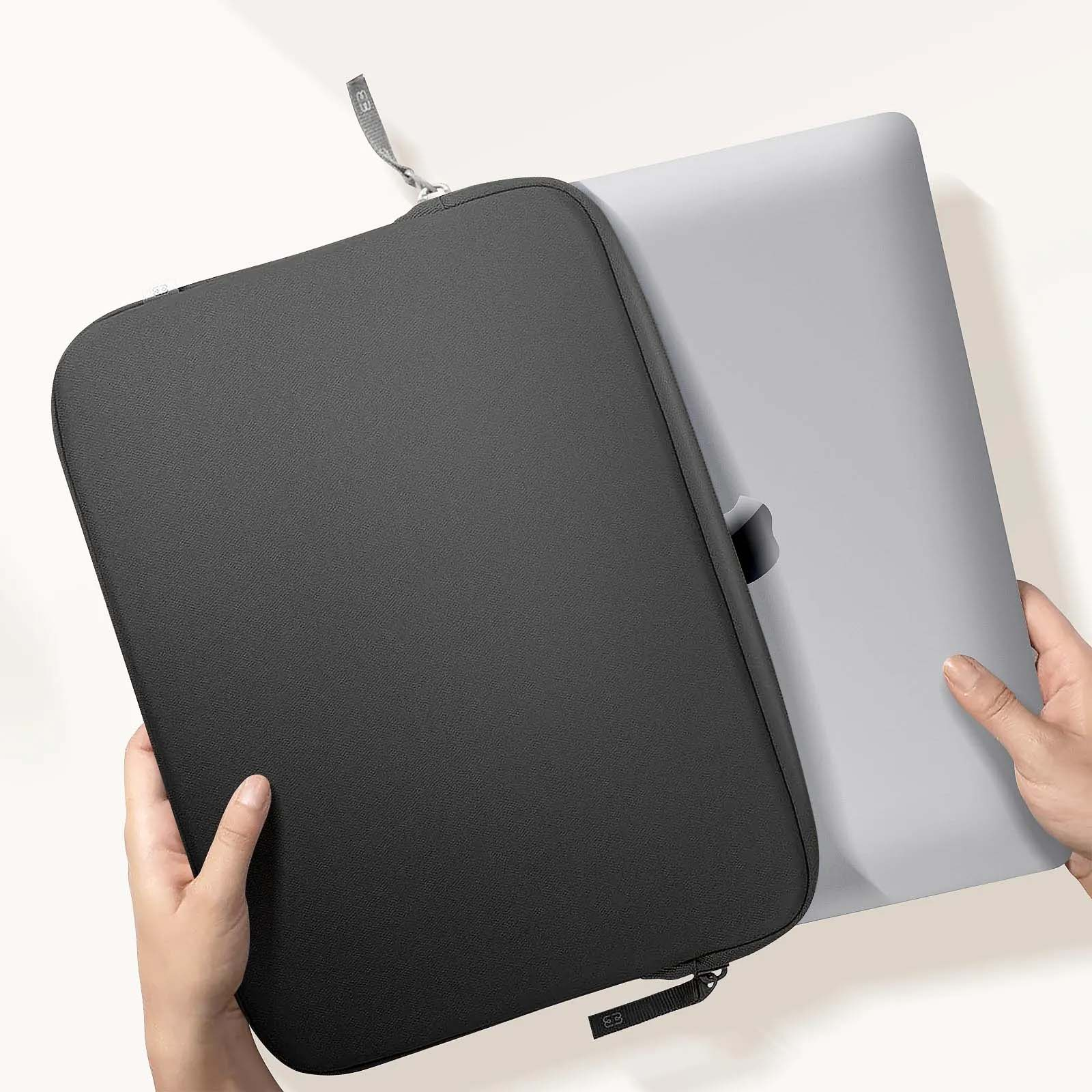 Una persona che tiene in mano un laptop e una custodia nera per laptop.